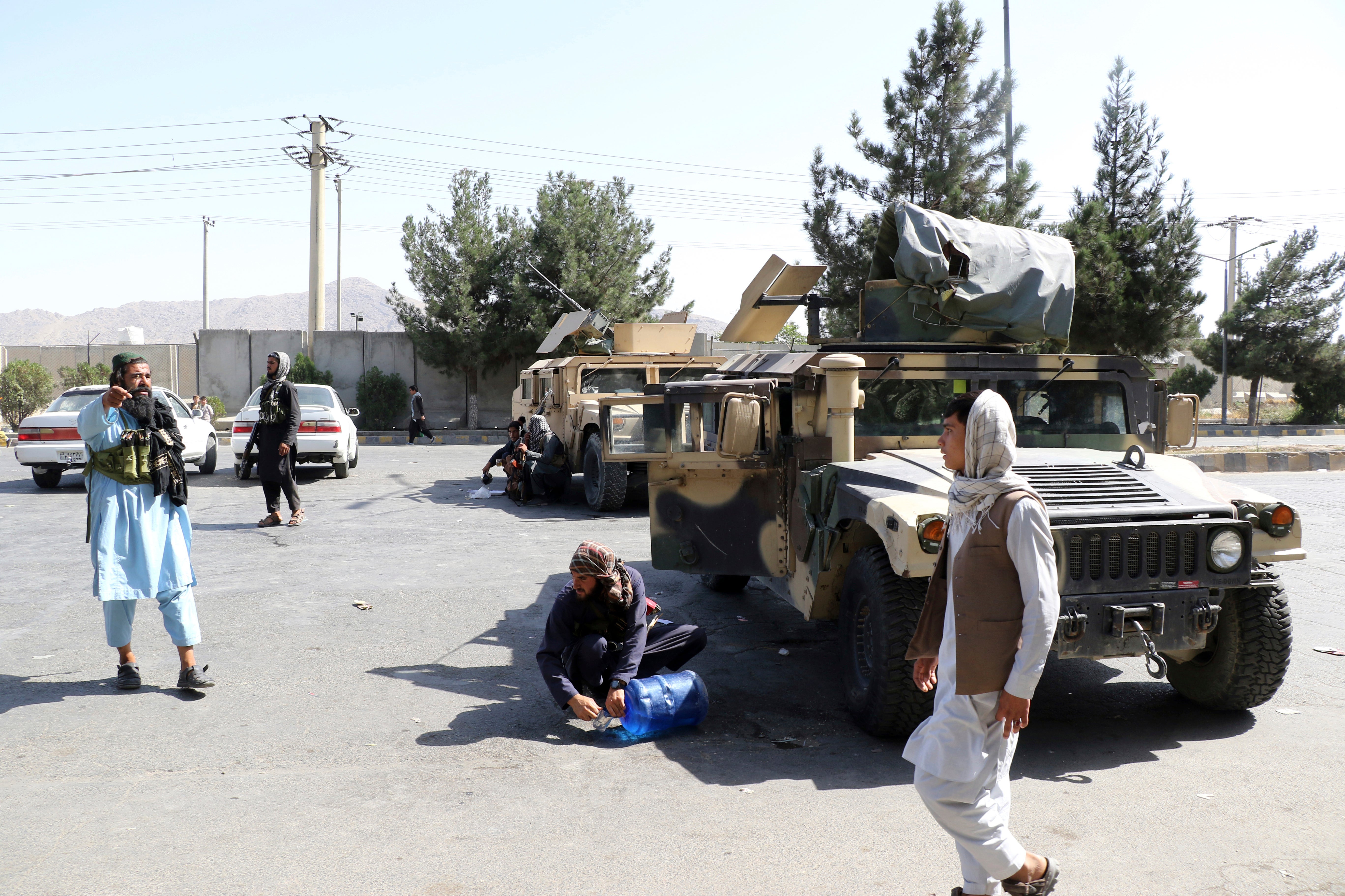 Taliban fighters stand guard outside Kabul airport
