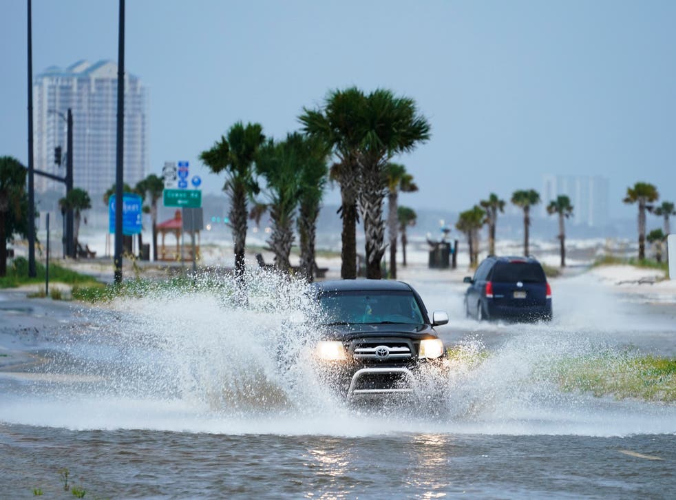 pCars drive through flood waters along route 90 as outer bands of Hurricane Ida arrive Sunday, Aug. 29, 2021, in Gulfport, Miss. (AP Photo/Steve Helber)/p