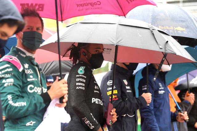 Drivers stand under umbrellas (John Thys, Pool Photo via AP)