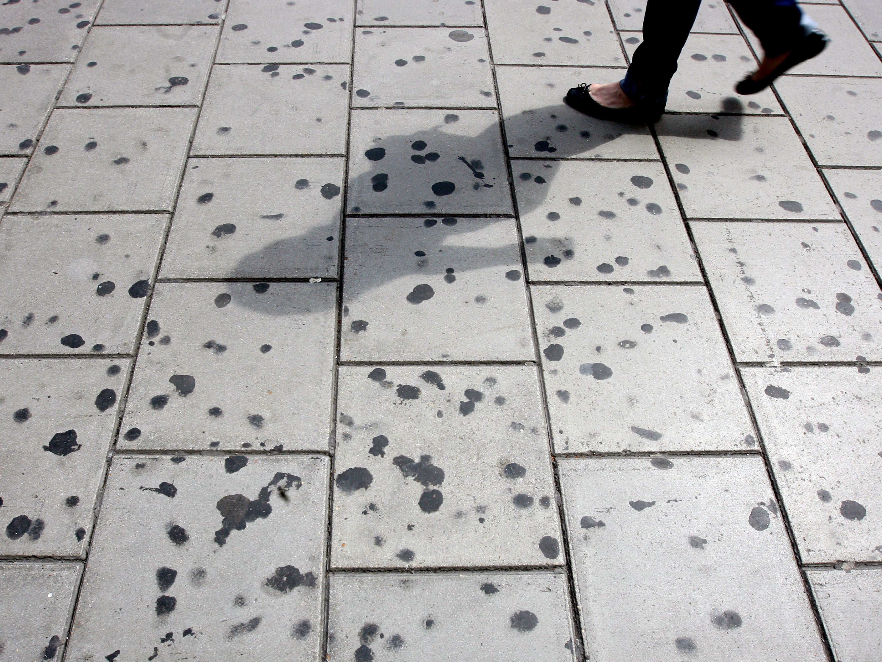 A woman walks by a pavement covered in chewing gum on Oxford Circus in 2008