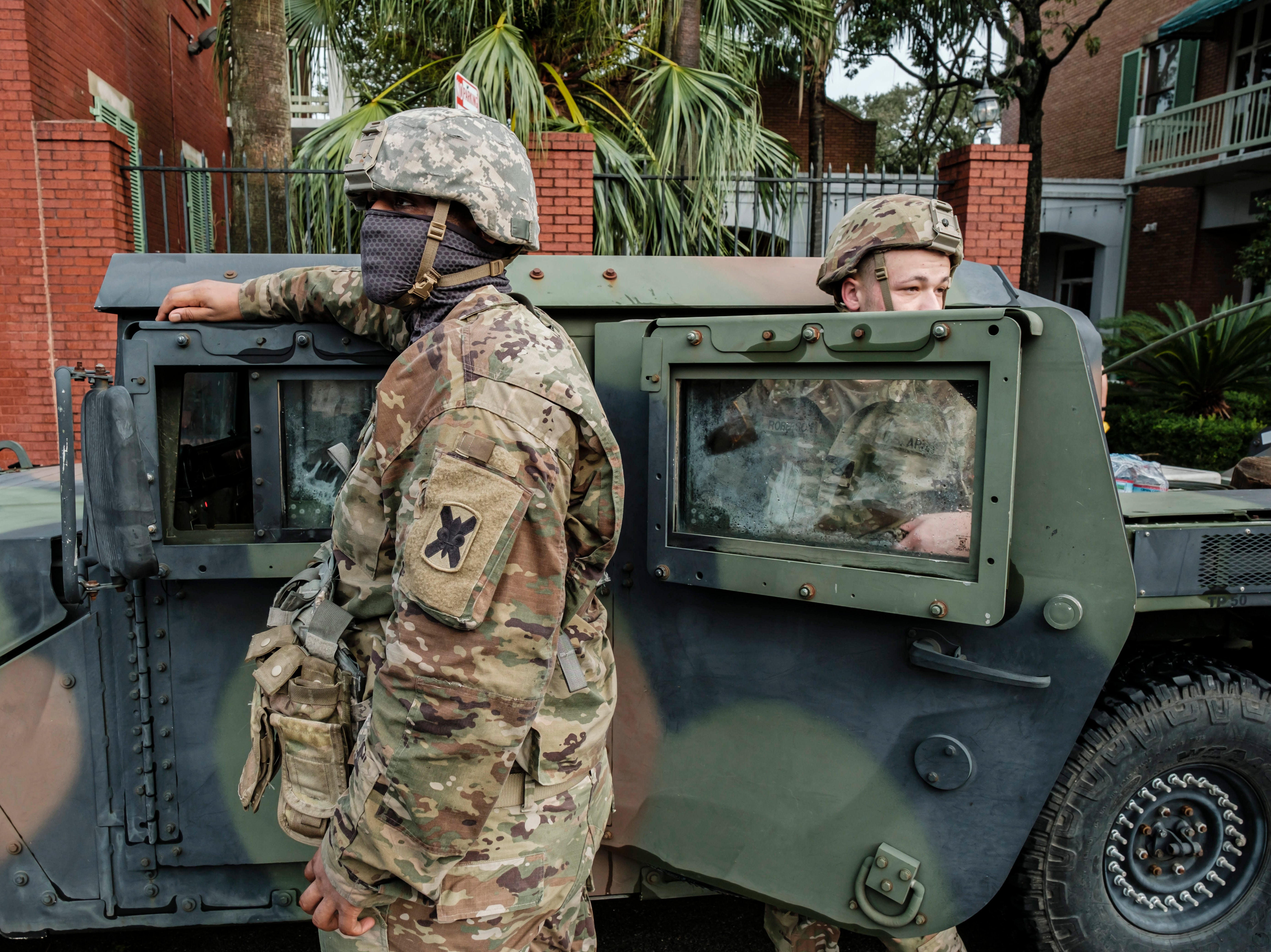 Members of the Louisiana National Guard stand outside their vehicles on North Rampart Street to help in Hurricane Ida recovery efforts