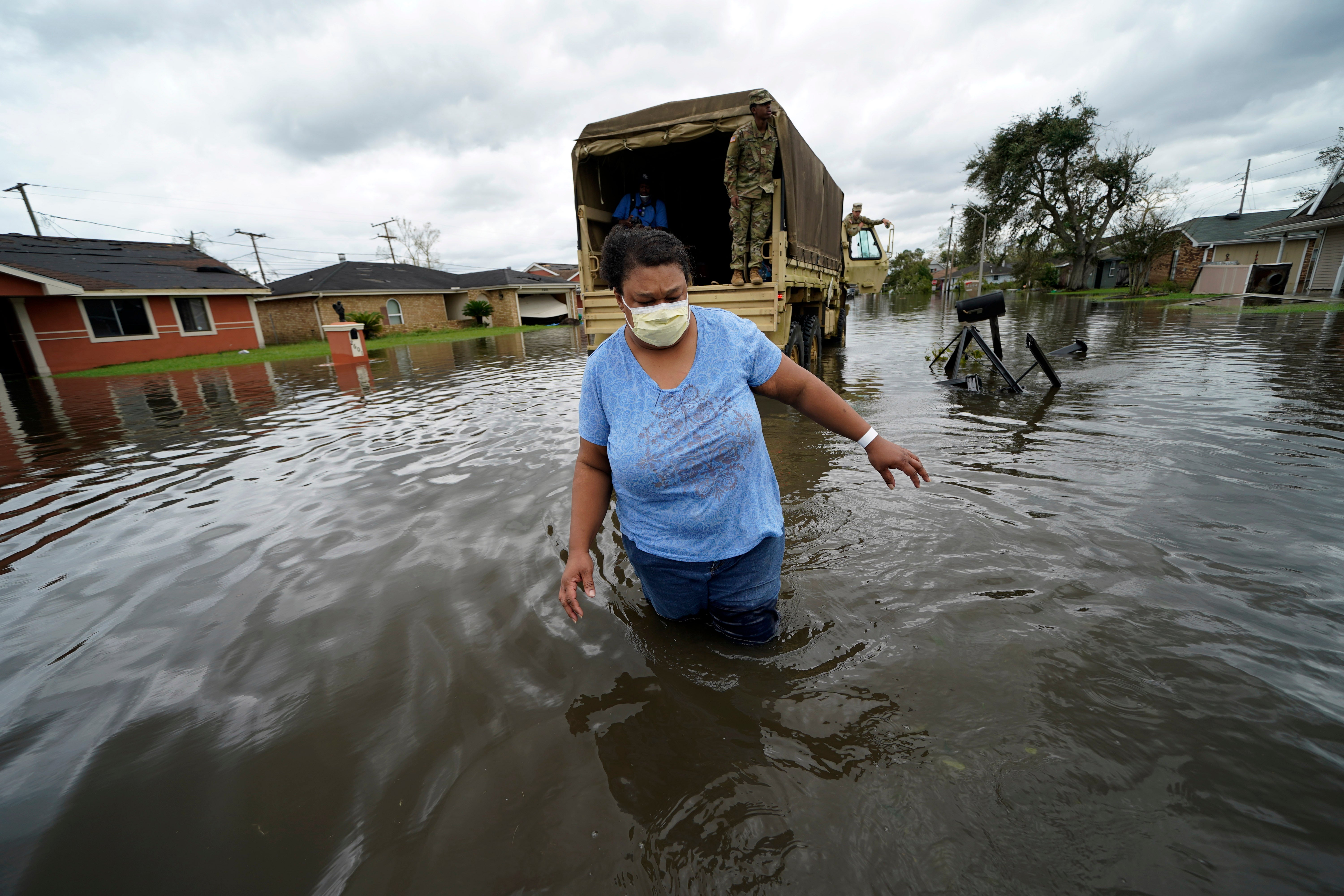 Jerilyn Collins wades through floodwaters after being transported by the Louisiana National Guard back to her home to retrieve medicine for herself and her father, after she evacuated from rising water in the aftermath of Hurricane Ida in LaPlace, Louisiana