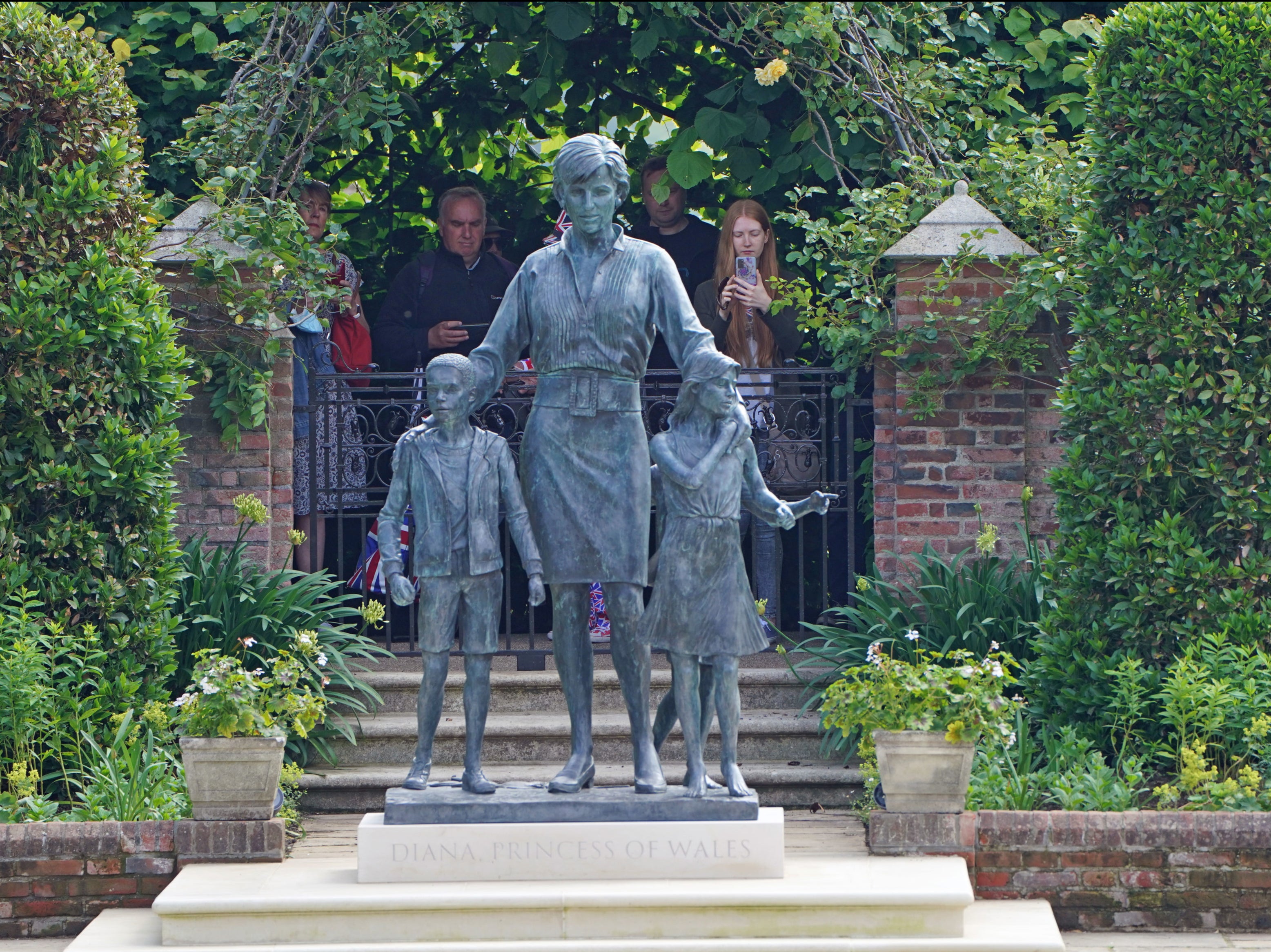 Los miembros del público ven la estatua de Diana, Princesa de Gales, en el Sunken Garden en el Palacio de Kensington, Londres