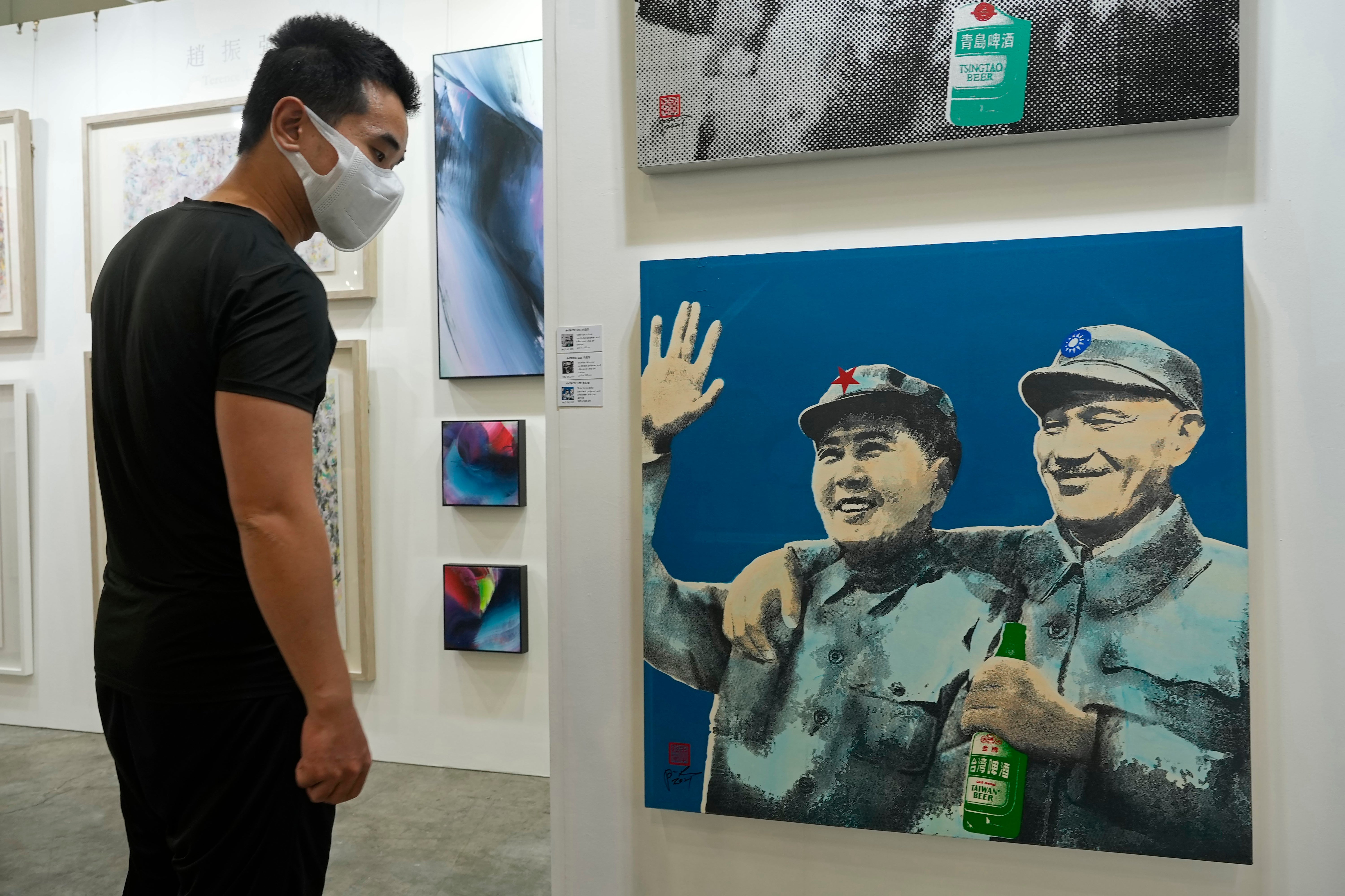 A visitor walks past at an artwork titled ‘Time for a drink’ created by Taiwan artist Patrick Lee