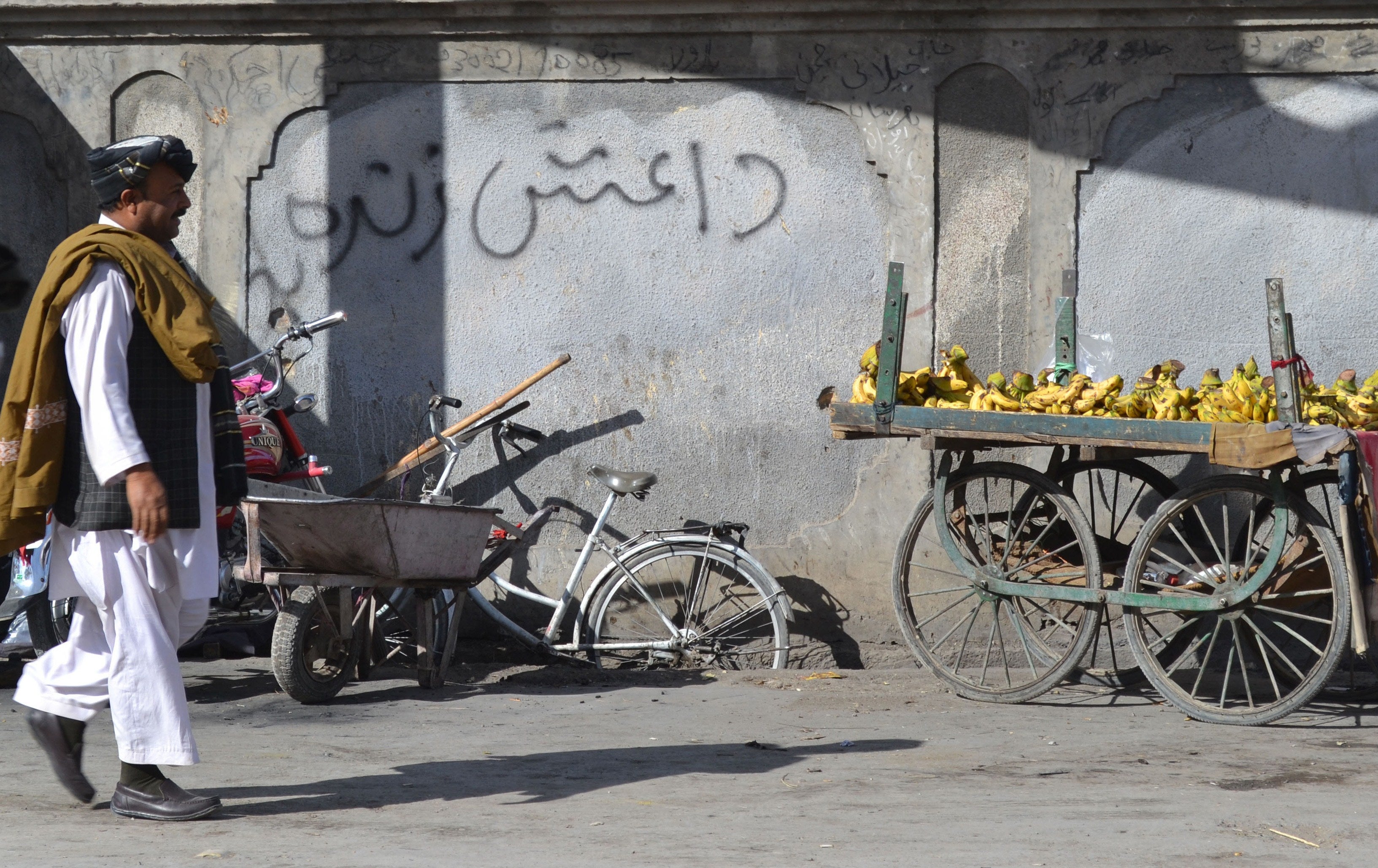 A Pakistani pedestrian walks past graffiti that reads ‘Daesh’, the arabic acronym for Isis, in Quetta