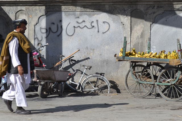 <p>A Pakistani pedestrian walks past graffiti that reads ‘Daesh’, the arabic acronym for Isis, in Quetta </p>