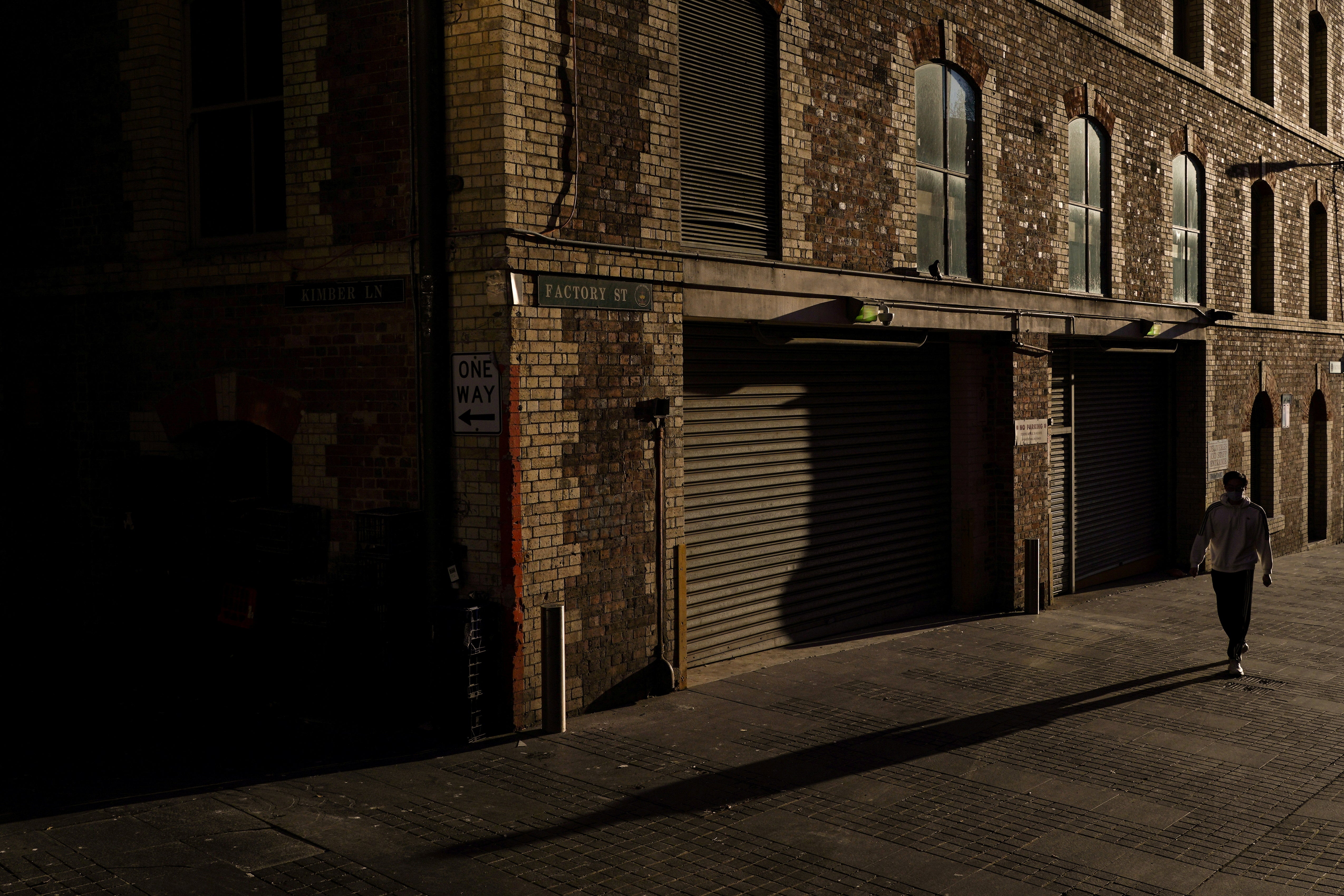 A man wearing a protective face mask walks through the quiet city centre during a lockdown to curb the spread of a coronavirus disease outbreak in Sydney last month