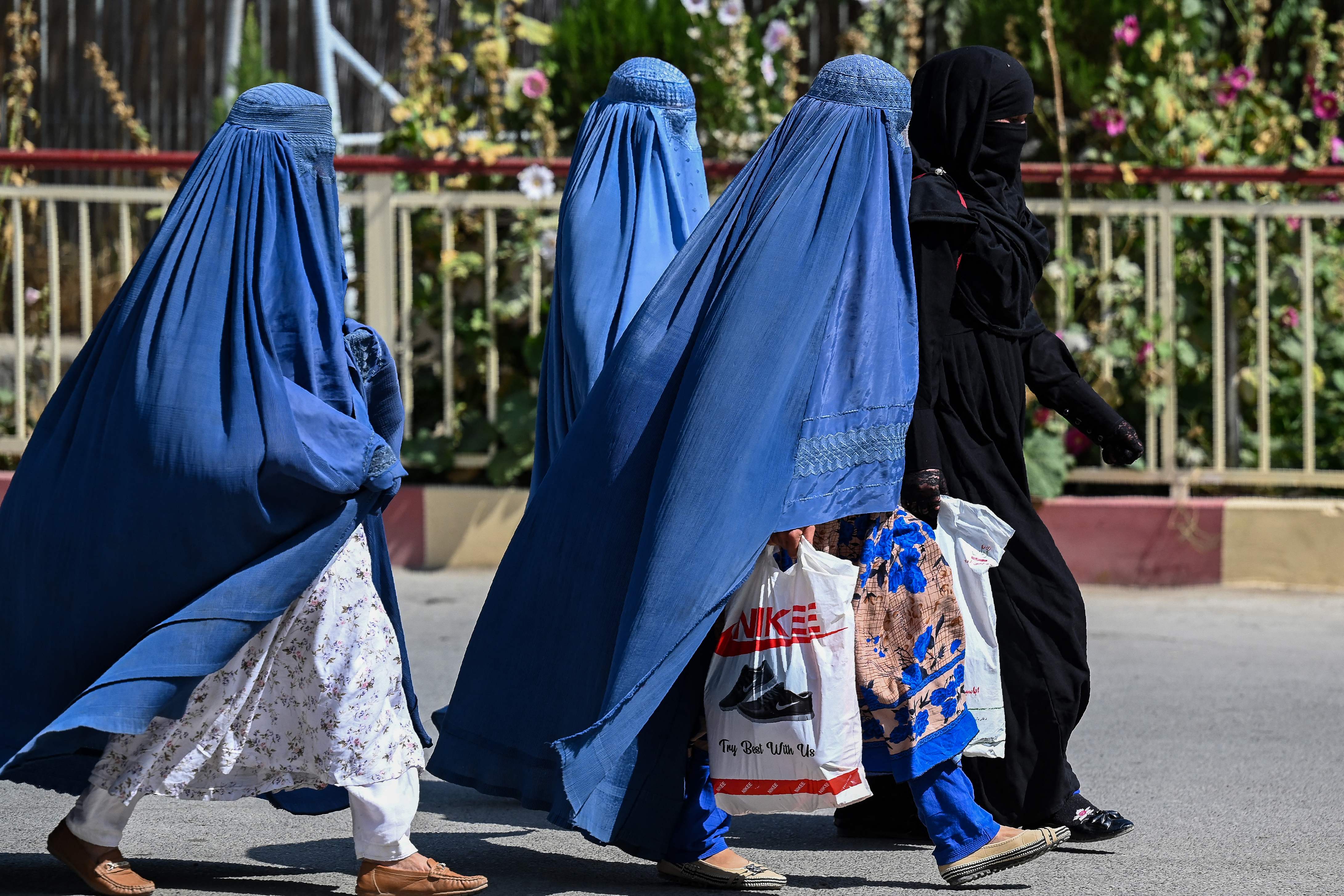 Burqa-clad Afghan women walk near the premises of Wazir Akbar Khan hospital in Kabul