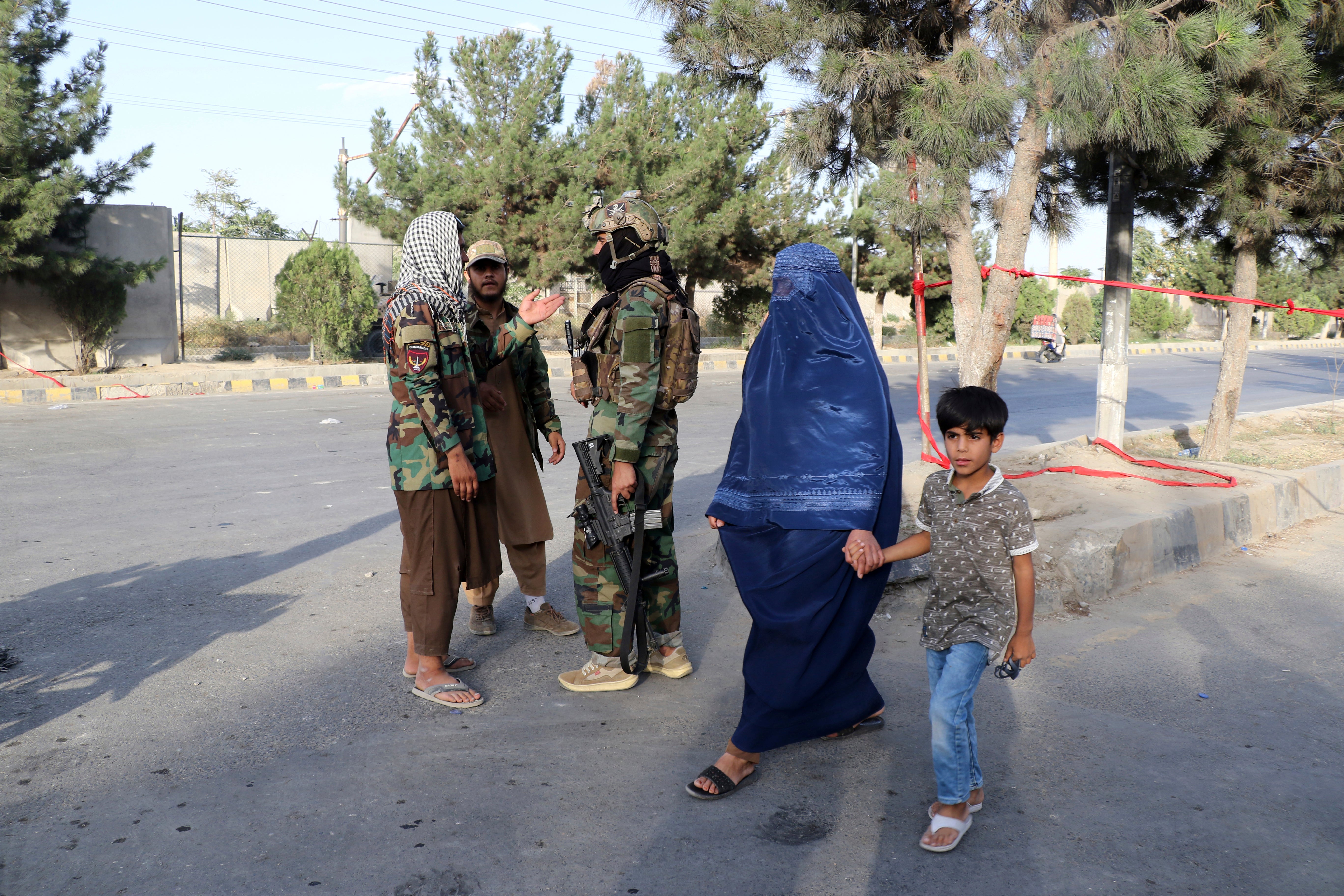 Taliban fighters stand guard at a checkpoint near the gate of Hamid Karzai international Airport in Kabul, Afghanistan