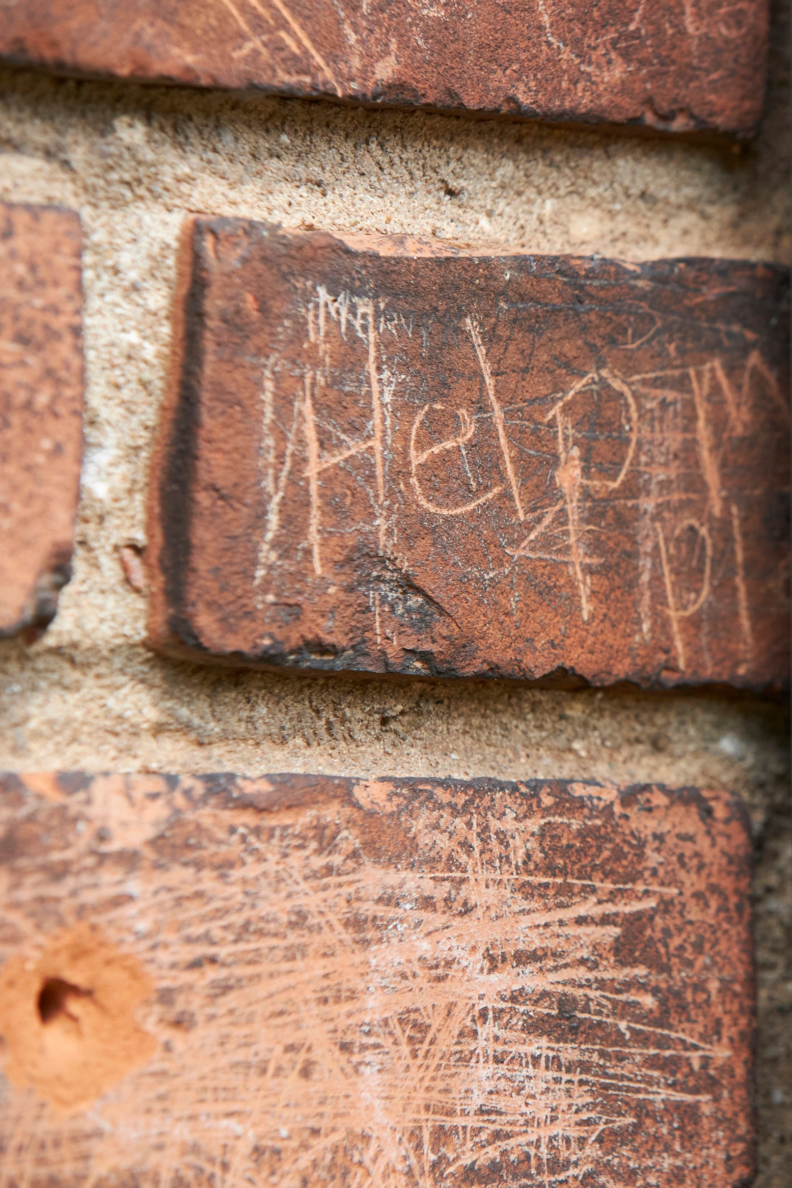 The words “Help me please” are etched into a brick at the former Mohawk Institute.