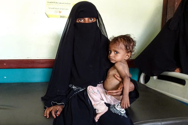 <p>A Yemeni woman holds a malnourished child at a clinic in the war-ravaged western province of Hodeida</p>