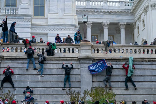 <p>Rioters climb the west wall of the the US Capitol in Washington on 6 January </p>