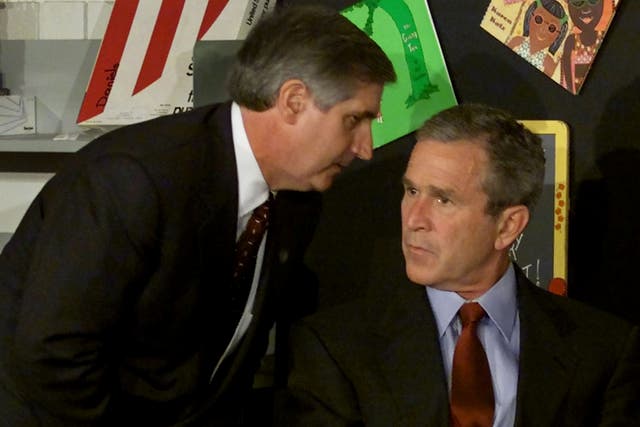 El presidente de los Estados Unidos, George W. Bush, escucha mientras el jefe de gabinete de la Casa Blanca, Andrew Card, le informa sobre un segundo avión que choca contra el World Trade Center.