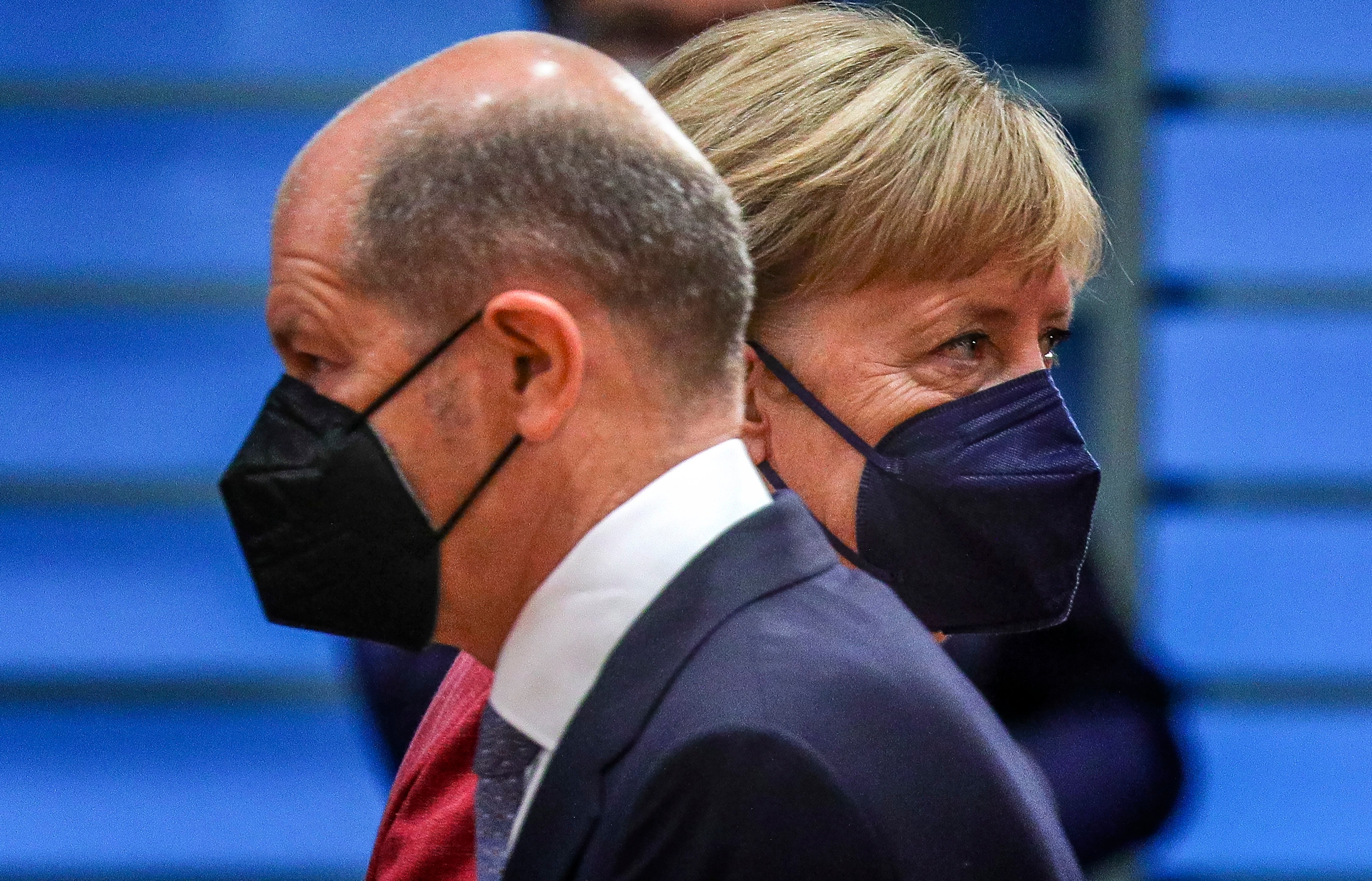 The German minister of finance, Olaf Scholz (left), passes by the German chancellor, Angela Merkel, at the weekly government cabinet meeting in Berlin