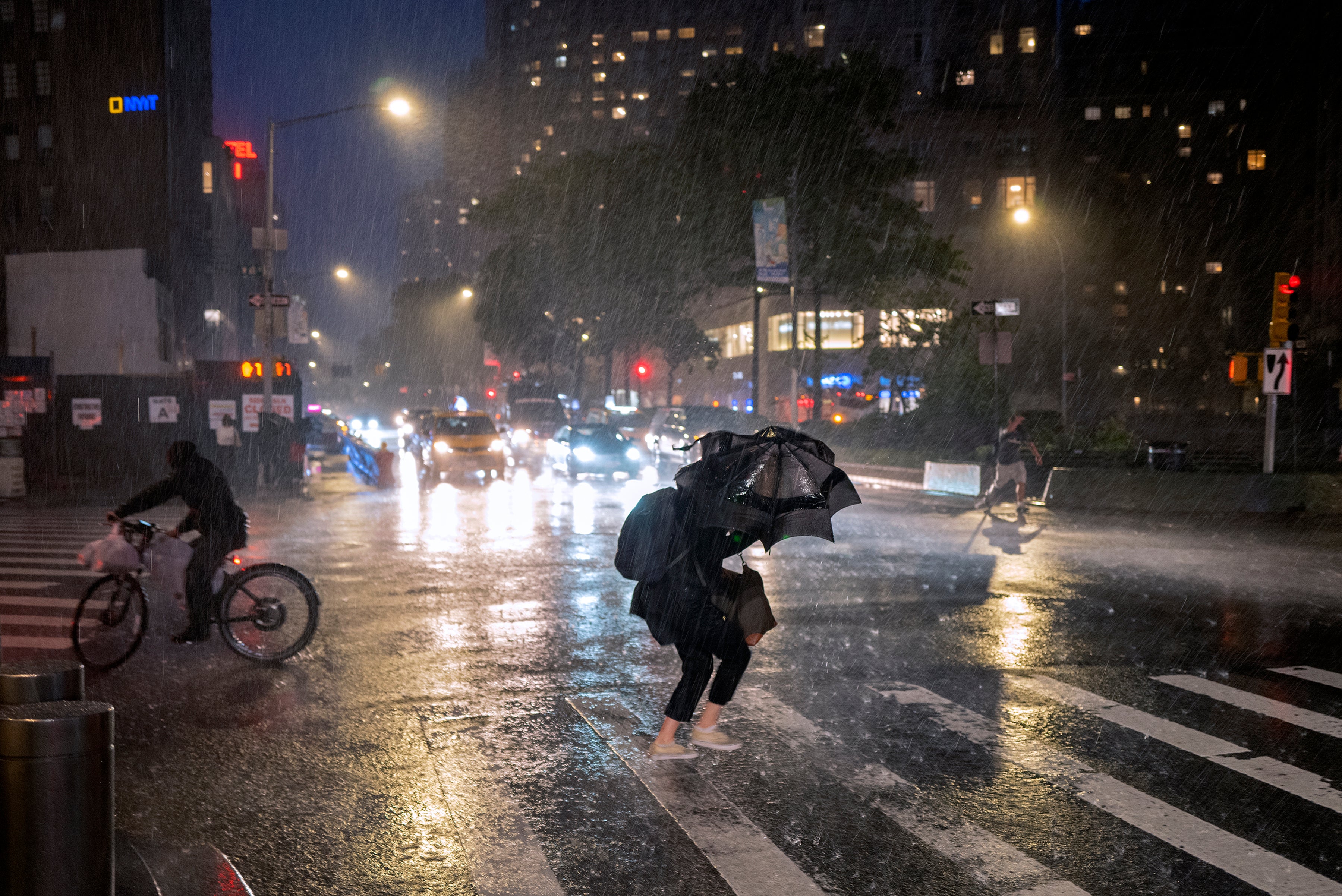<p>Pedestrians take cover near Columbus Circle in New York Wednesday, Sept. 1, 2021, as the remnants of Hurricane Ida remained powerful while moving along the Eastern seaboard</p>