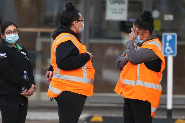 <p>Lynn Mall staff comfort each other as they wait to leave with police after a violent extremist took out a terrorist attack stabbing six people before being shot by police on 3 September 2021 in Auckland, New Zealand</p>
