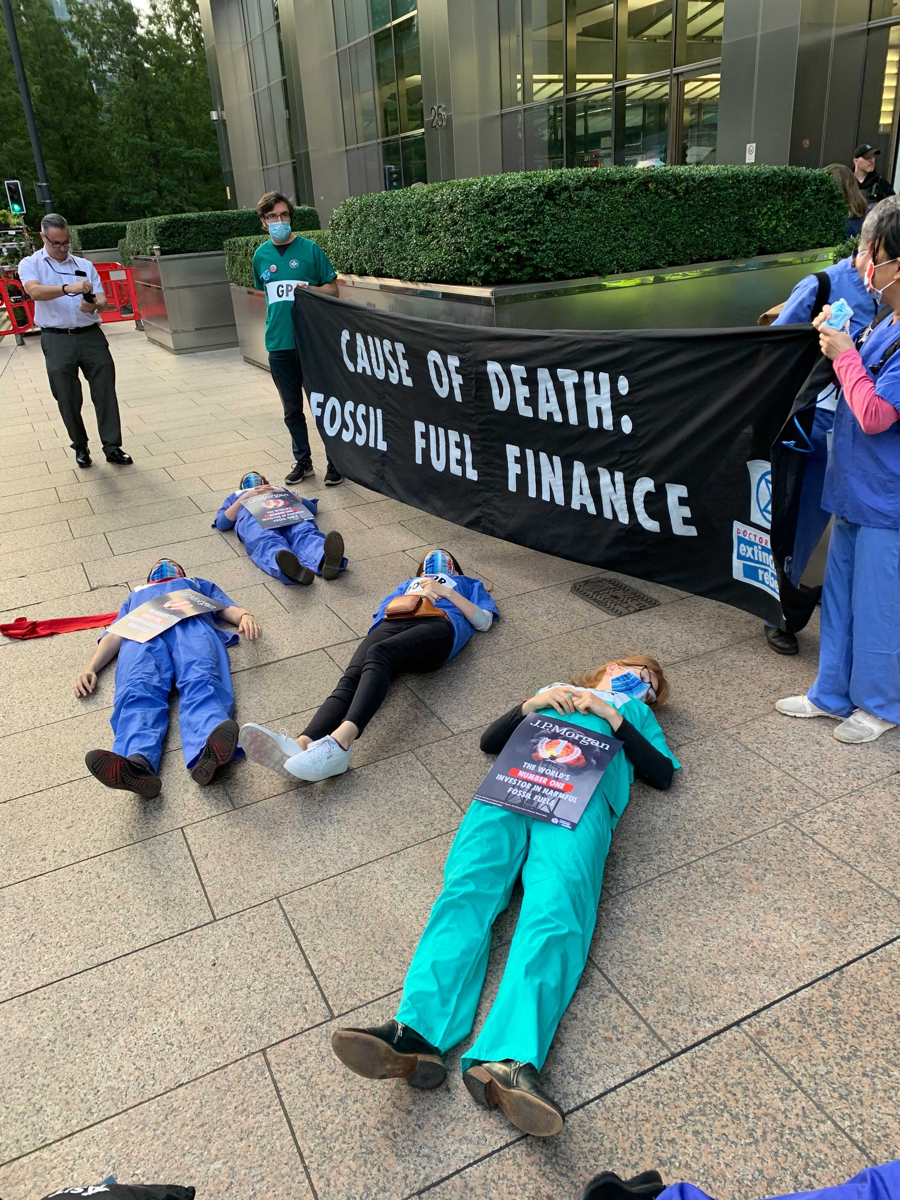 Protesters dressed in their scrubs lay on the floor and held banners in Canary Wharf
