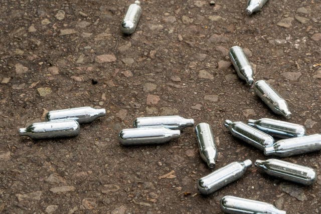 <p>Nitrous oxide cartridges lie empty on the ground in a rural area of the UK </p>