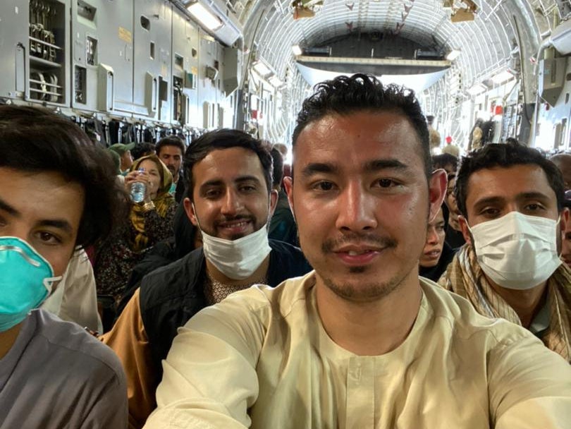 Hamed Ahmadi, front, joins other evacuees from Afghanistan after the Taliban took control back of the country