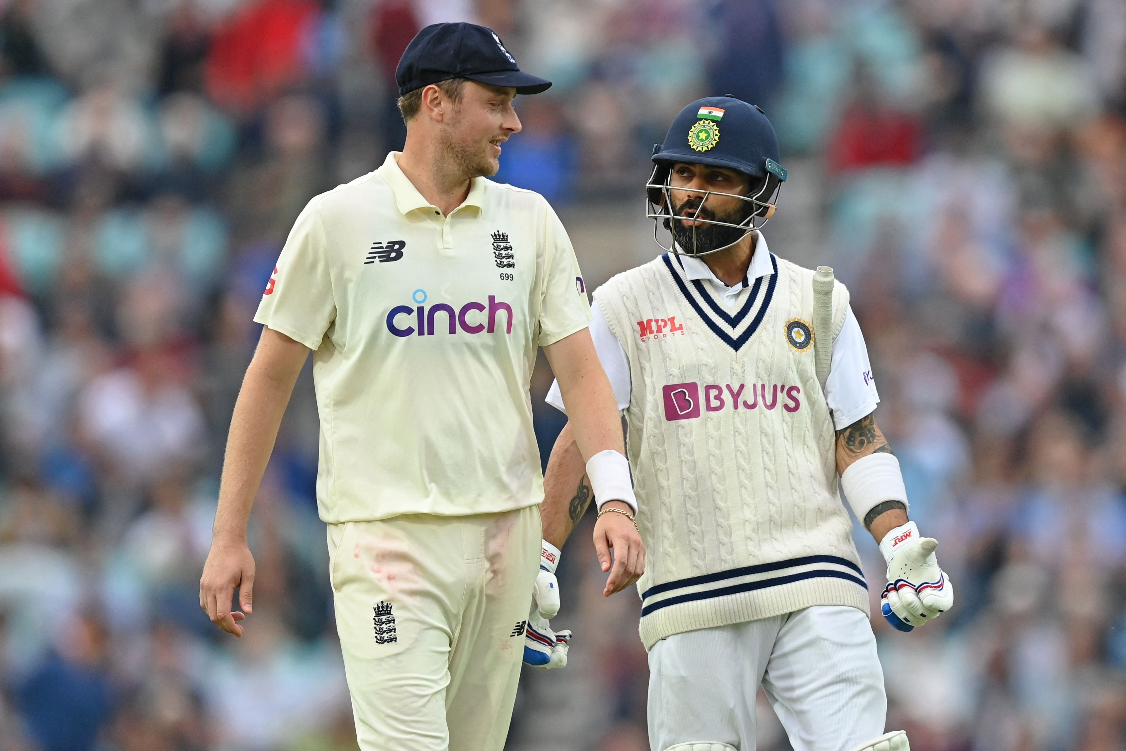 Ollie Robinson chats with Virat Kohli as players leave the field