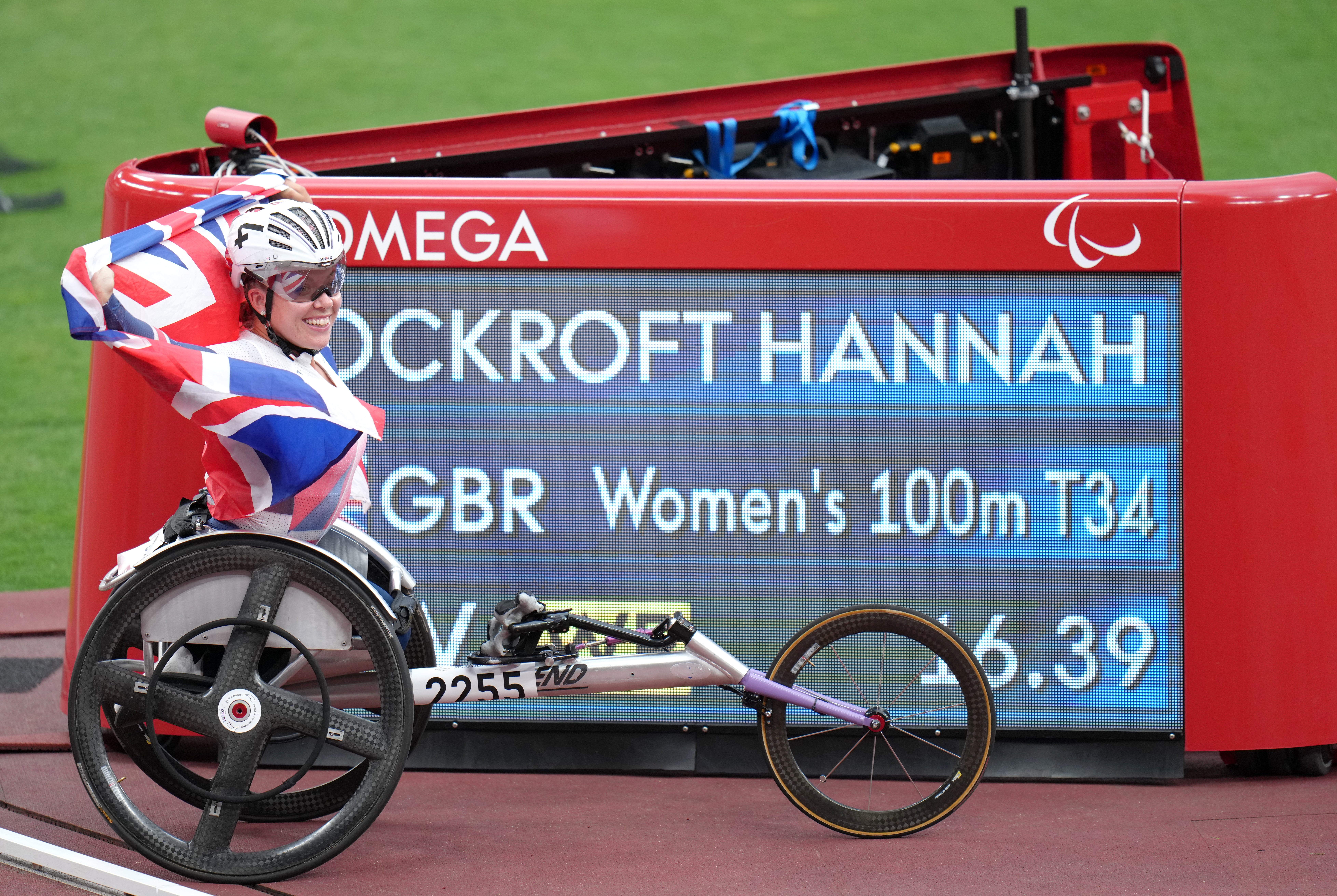 Hannah Cockroft poses with the scoreboard showing her new world record time after winning the women’s 100m T34 final (Tim Goode/PA)