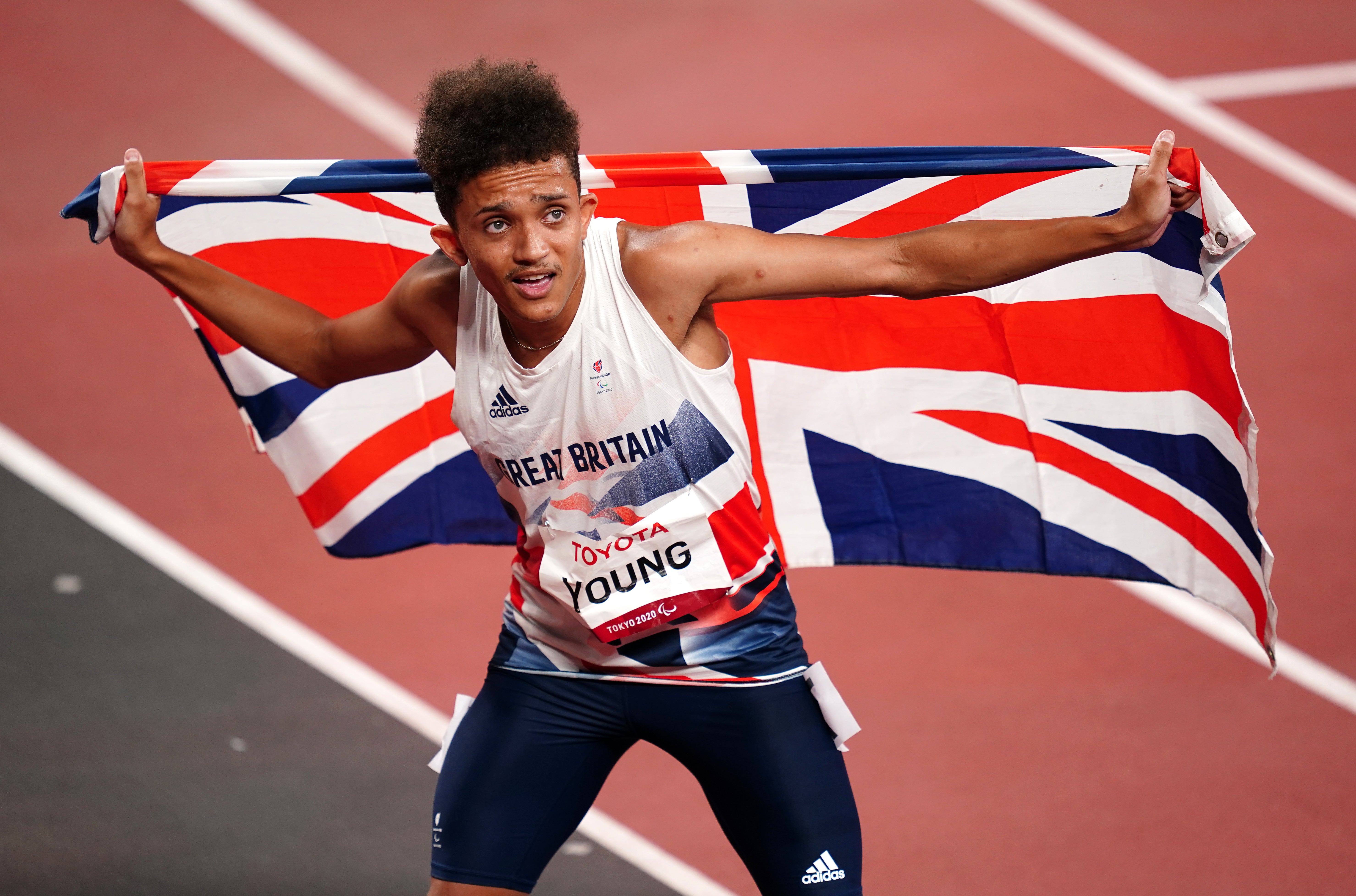 Thomas Young with the union flag after winning gold in the men’s 100m – T38 (John Walton/PA)