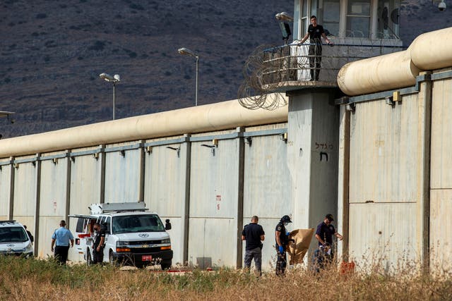 <p>Israeli security personnel stand together outside the walls of Gilboa prison after six Palestinian militants broke out of it in north Israel</p>