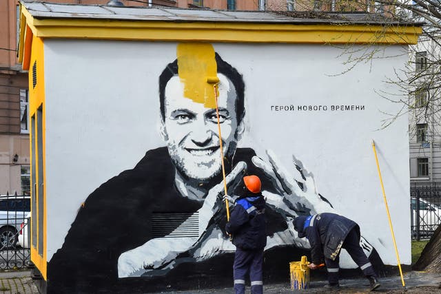 <p>a worker paints over graffiti of jailed Kremlin critic Alexei Navalny in Saint Petersburg. The inscription reads: "The hero of the new times". </p>