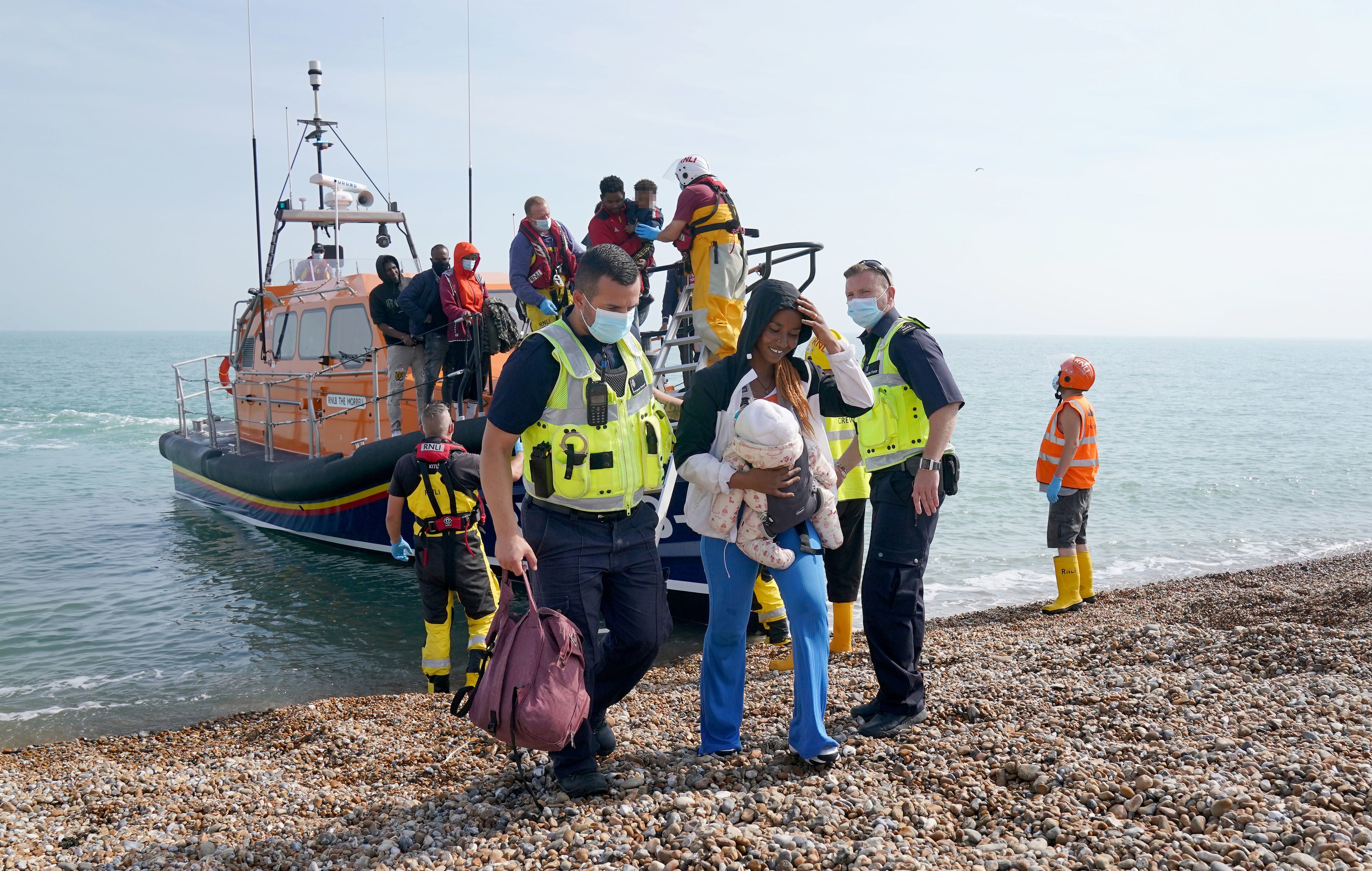 A group of people thought to be migrants are brought ashore from the local lifeboat at Dungeness in Kent, after being picked-up following a small boat incident in the Channel on Monday
