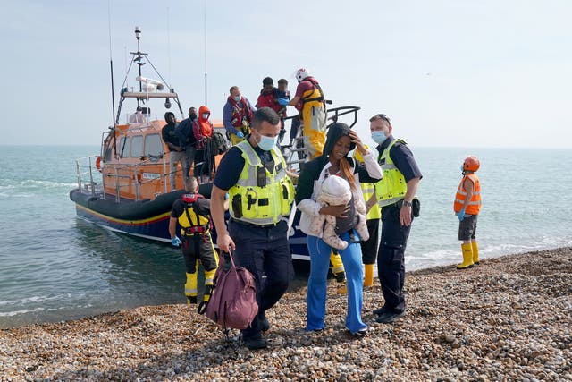 <p>A group of people thought to be migrants are brought ashore from the local lifeboat at Dungeness in Kent, after being picked-up following a small boat incident in the Channel on Monday</p>