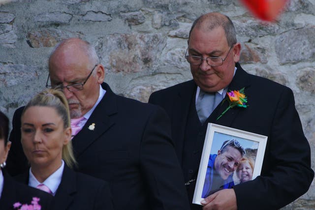 <p>Mourners carrying a photograph of Lee and Sophie Martyn leave the church after the pair’s funeral in Plymouth</p>