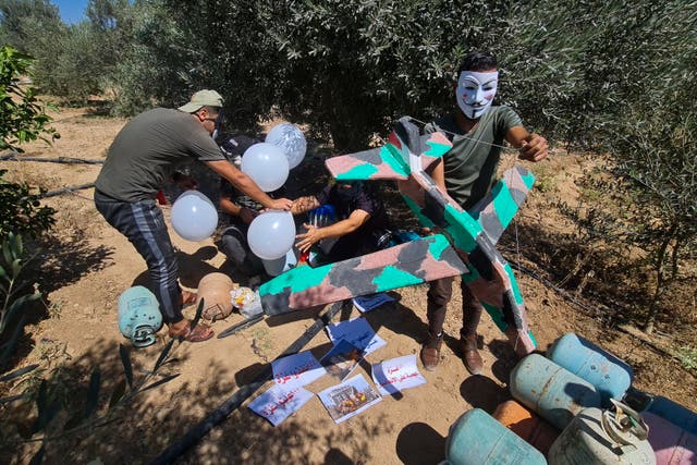 <p>Masked Hamas-affiliated operatives launched balloons towards Israel, next to the eastern border of Gaza Strip, prompting Israel to retaliate with air </p>