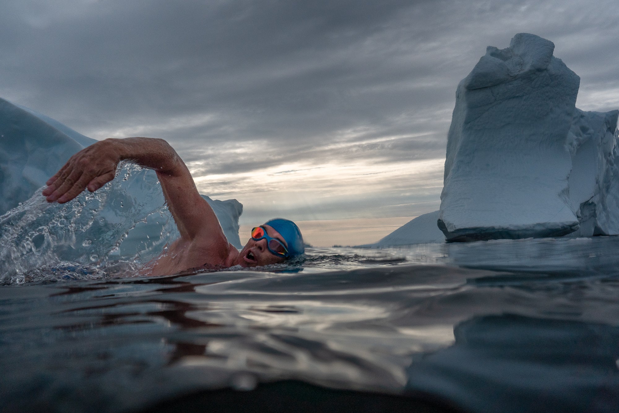 Lewis Pugh swimming among icebergs to to highlight the impacts of the climate crisis