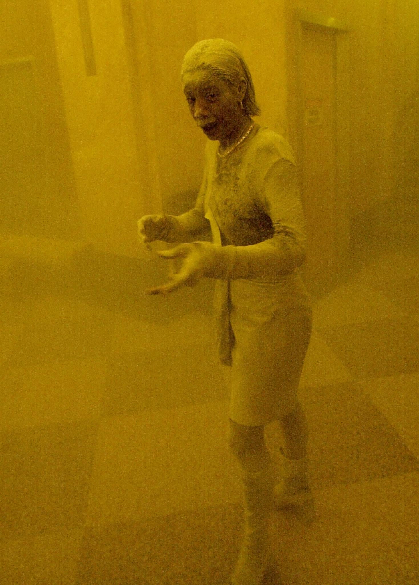 Marcy Borders stands covered in dust as she takes refuge in an office building following the collapse of the Twin Towers
