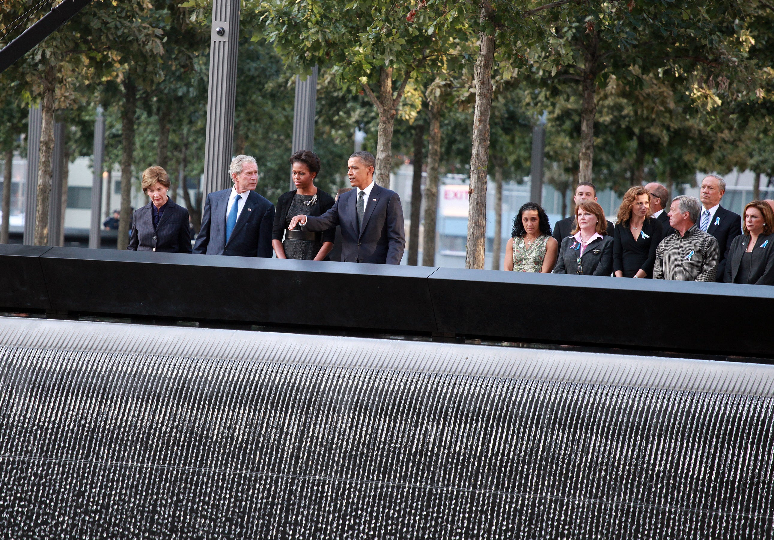 The Obamas and the Bushes pause for a moment of reflection with family members of victims at the North Pool of the 9/11 Memorial, 11 September 2011