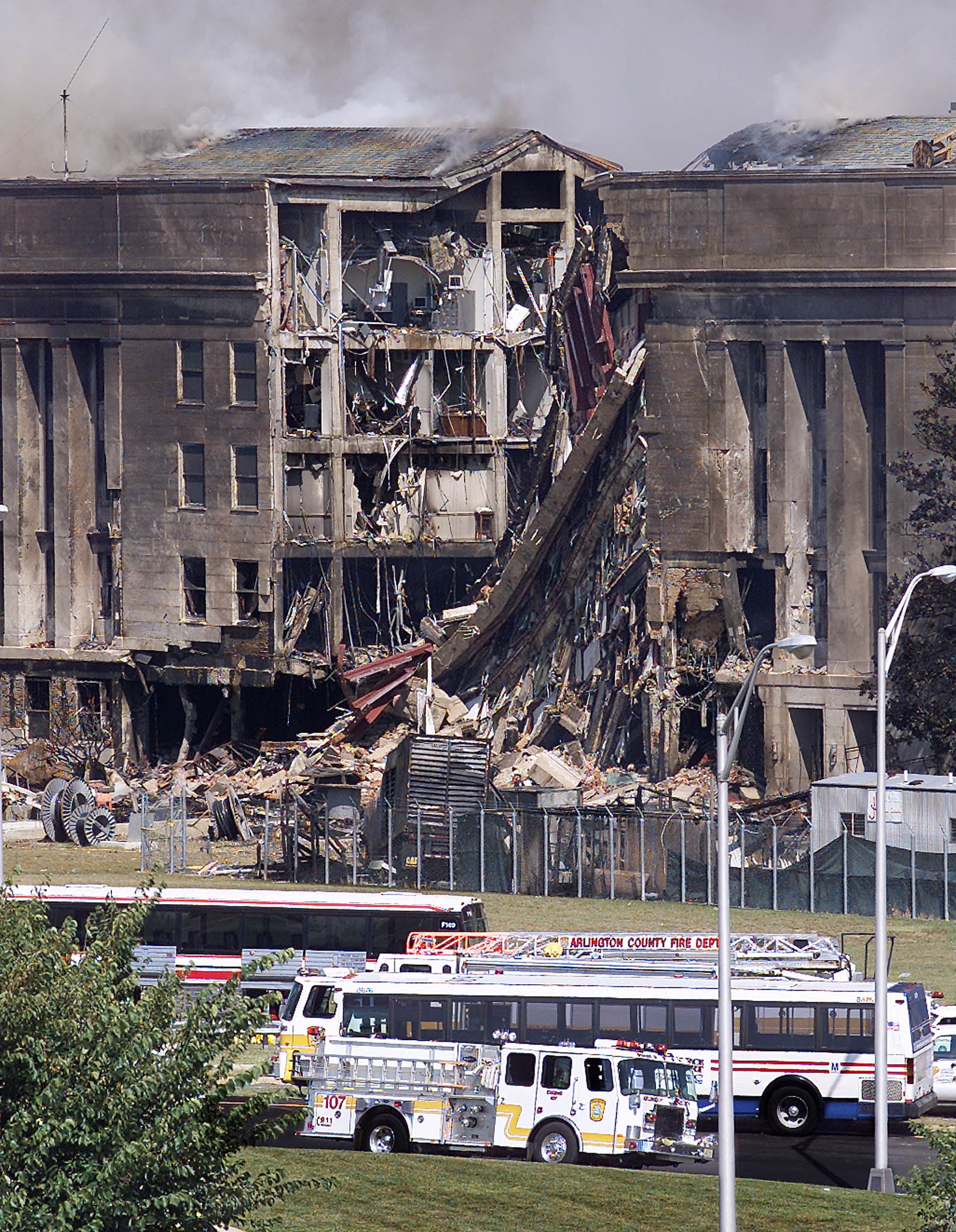 Emergency vehicles stand before a damaged wall of the Pentagon