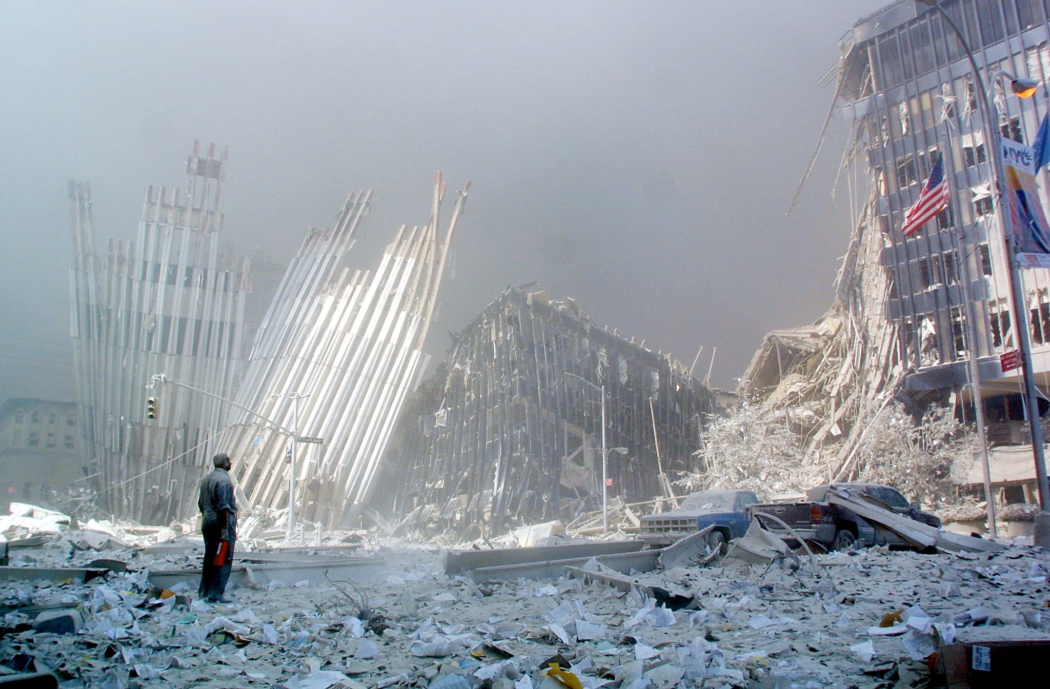 A man stands in the rubble, and calls out asking if anyone needs help, after the collapse of the first of the Twin Towers