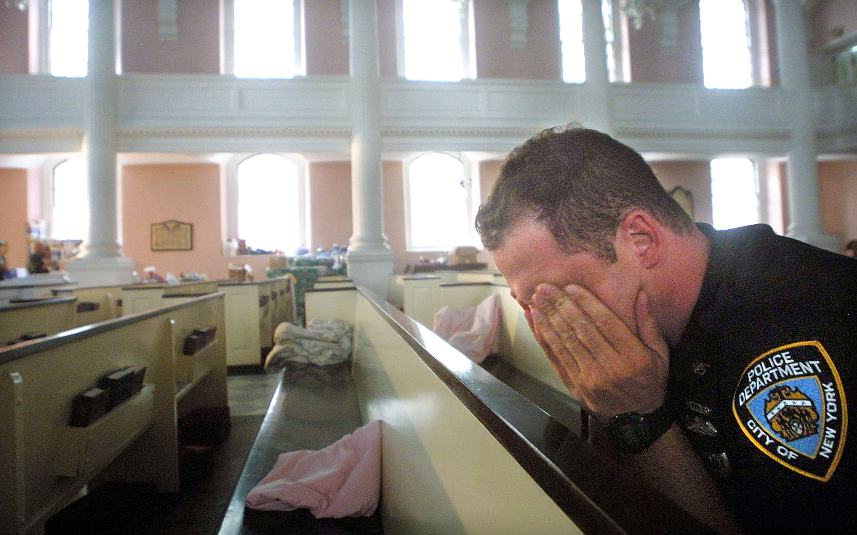 NYPD police officer Ken Radigan rubs his eyes after briefly sleeping in a pew at St Paul’s Episcopal Chapel, near the site of the World Trade Center attack. The chapel served as a relief area for rescue workers