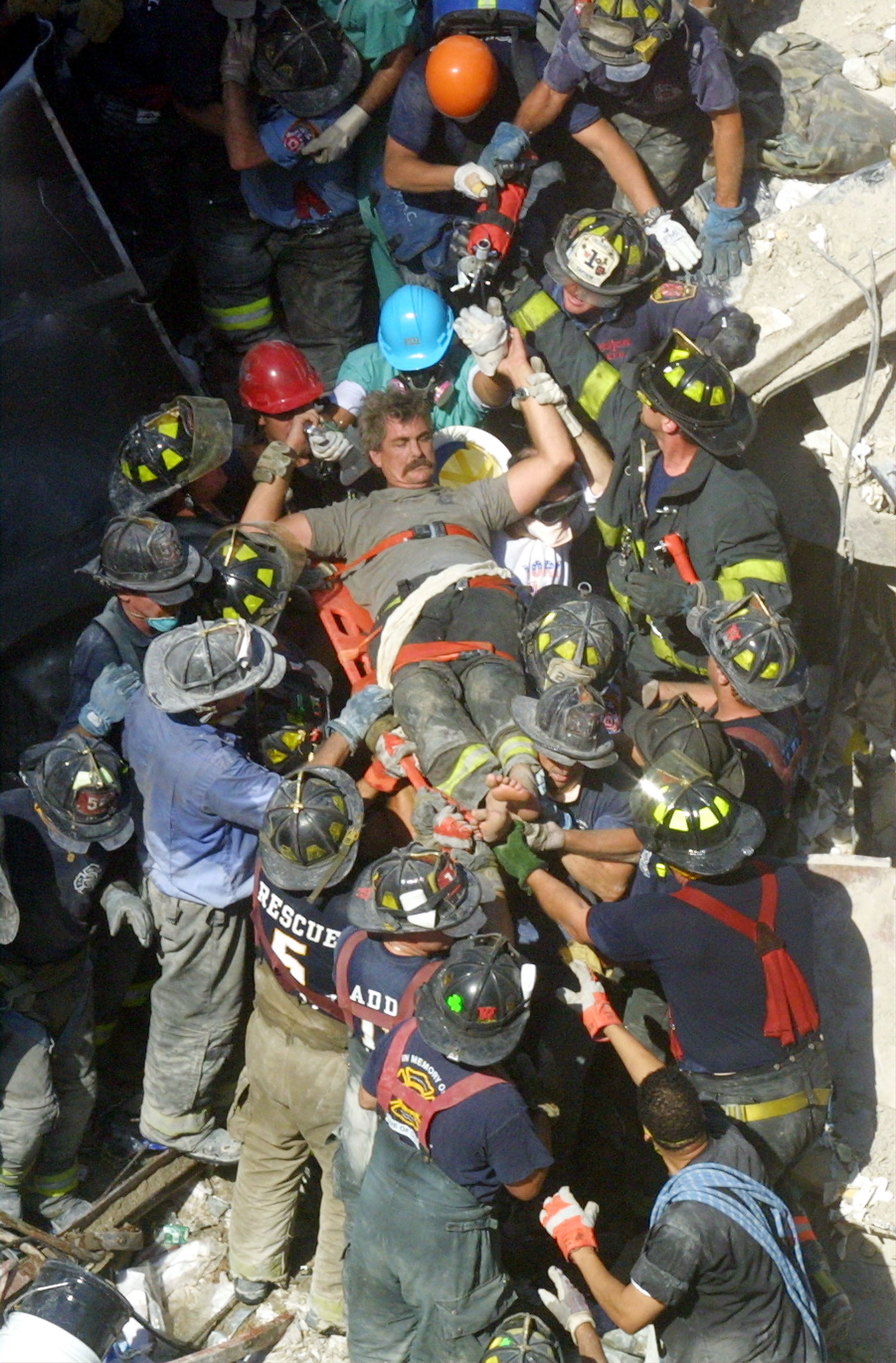 A rescue worker is pulled from the rubble