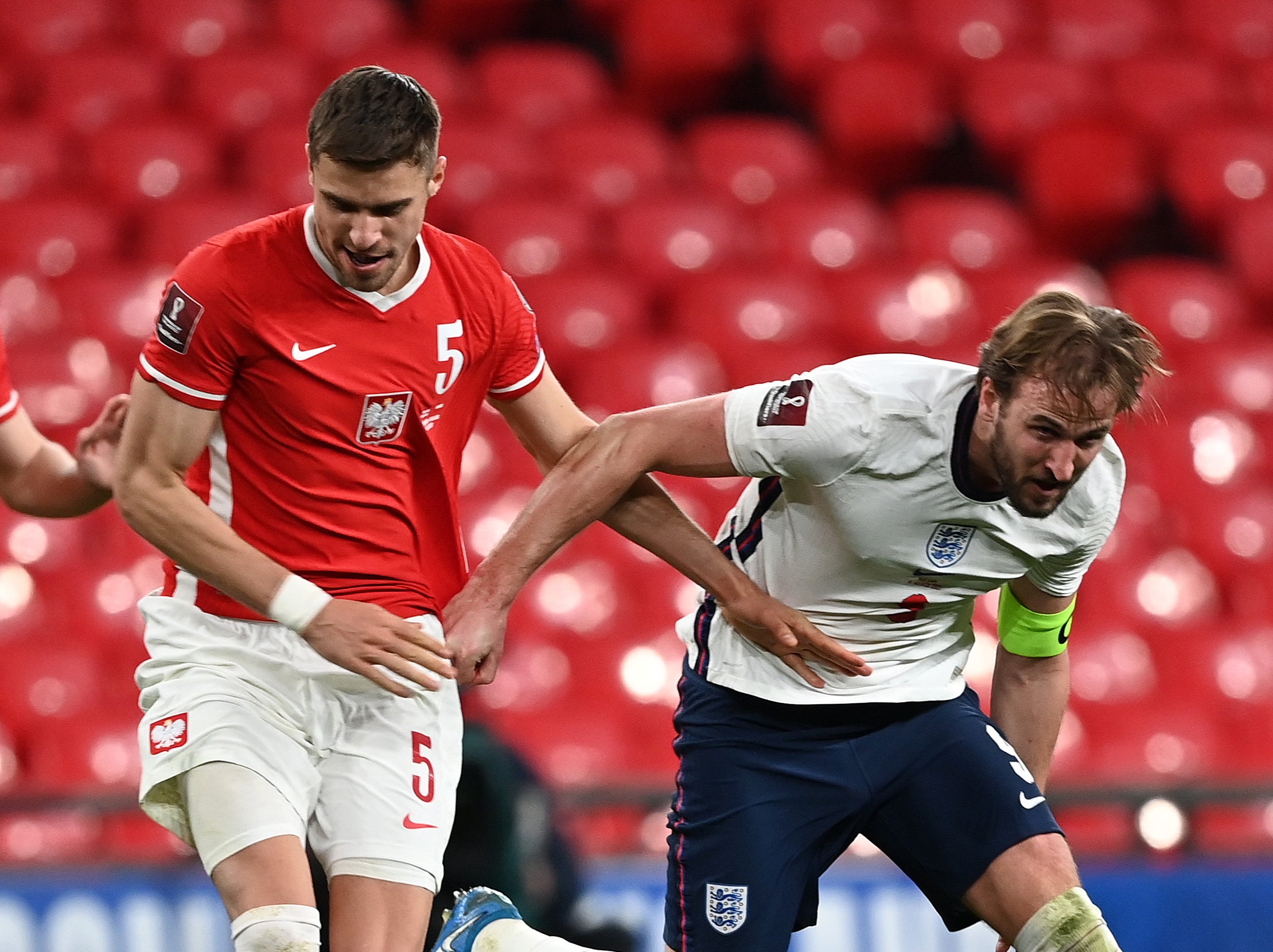 England captain Harry Kane vies for the ball with Poland’s Jan Bednarek