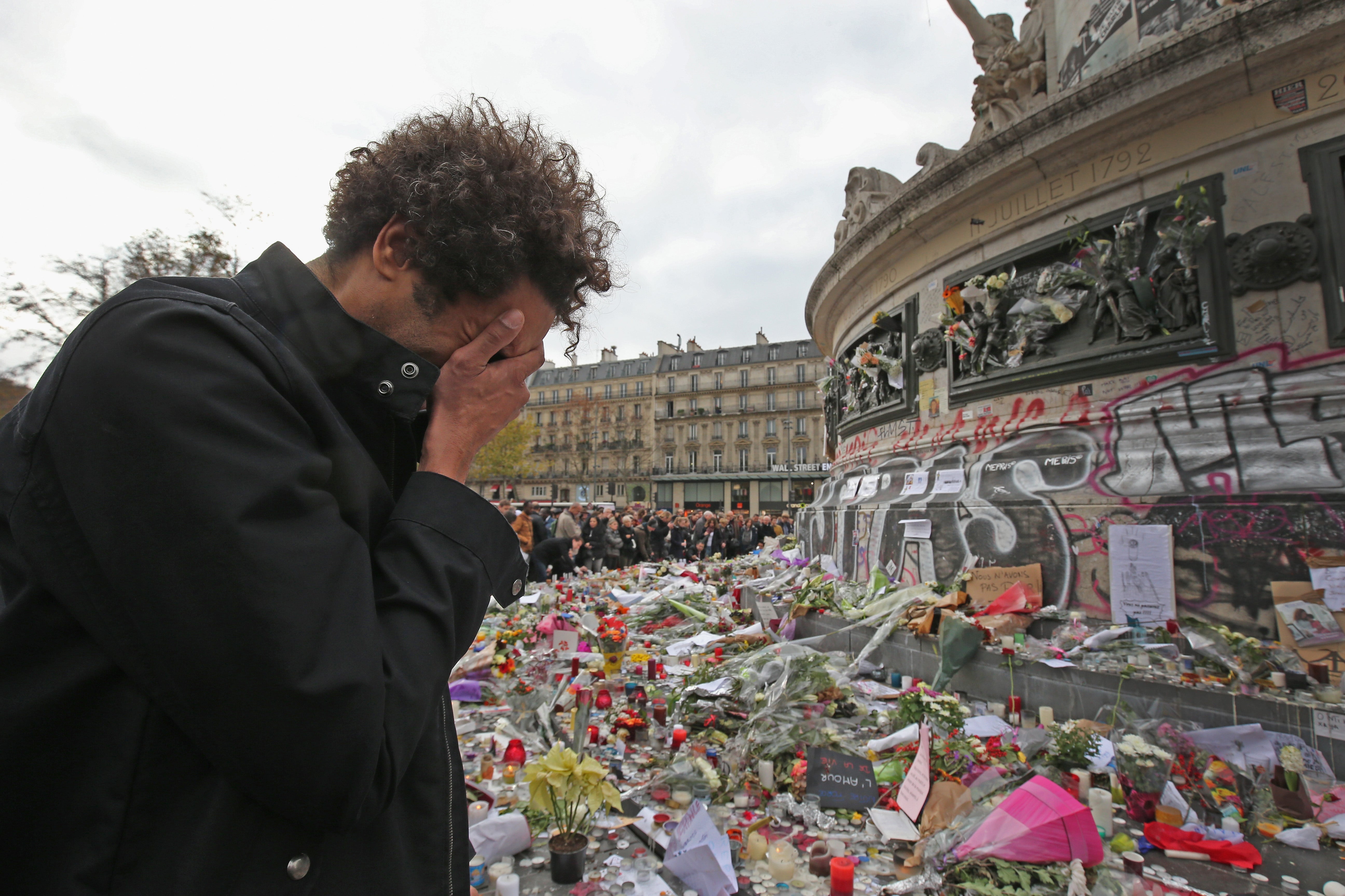 People gather to observe a minute-silence at the Place de la Republique on 16 November 2015