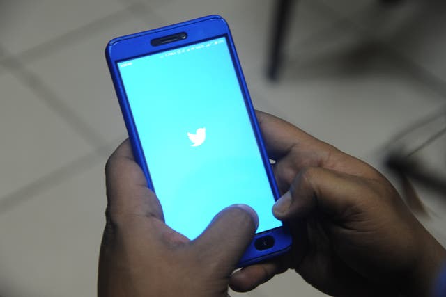 <p>Indian man poses for a photograph using Twitter on his cellphone in Siliguri </p>