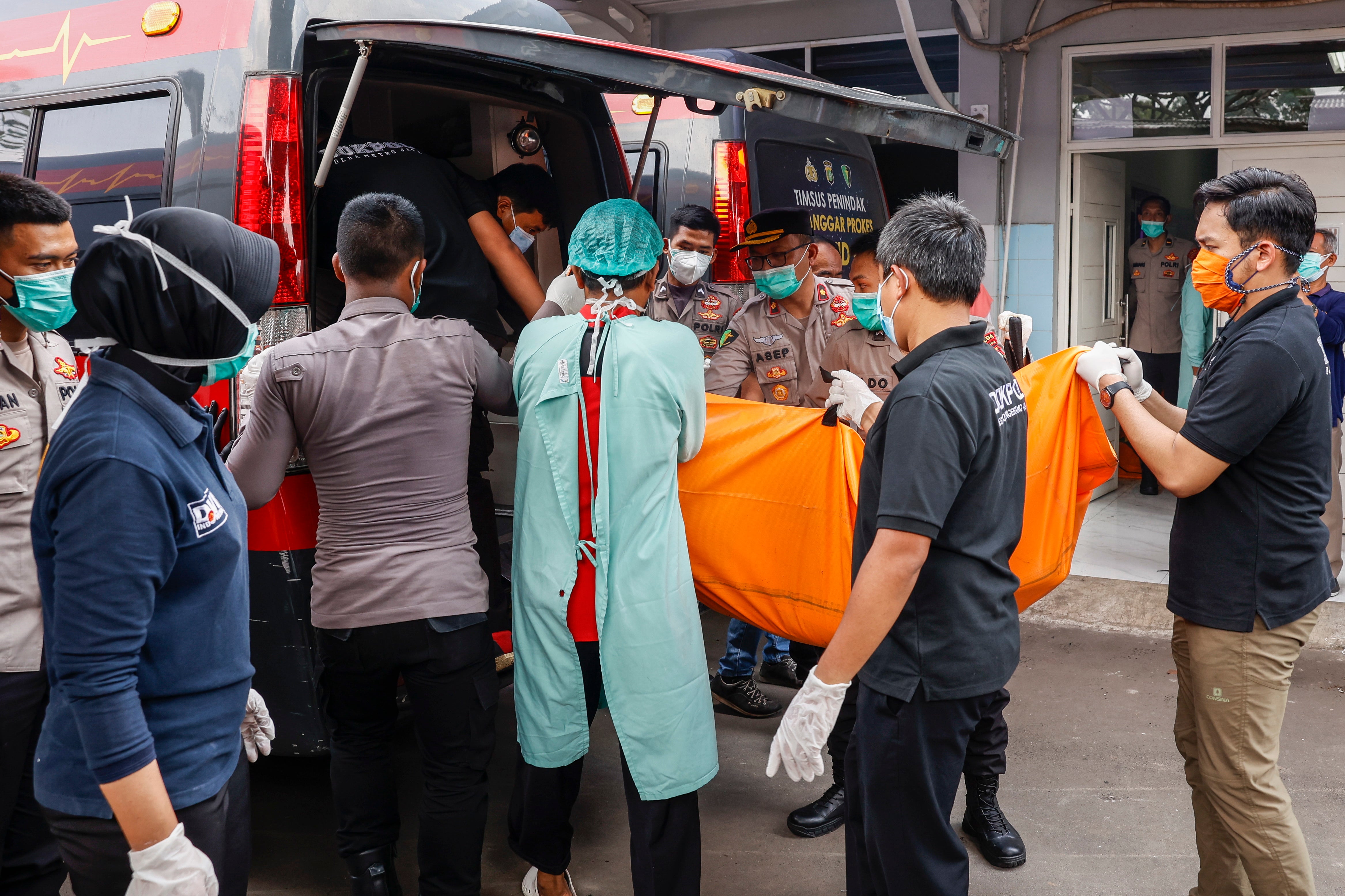 Disaster Victims Identification (DVI) police officers load a body bag onto a van in the aftermath of a prison fire at a hospital in Tangerang, Banten, Indonesia, 8 September 2021