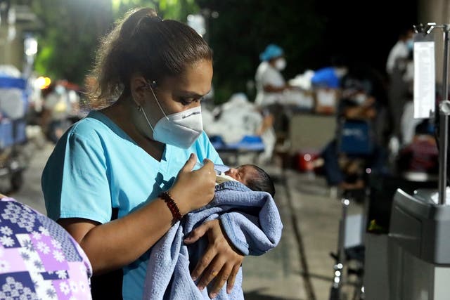 <p>A nurse takes care of a baby outside a hospital after patients and personnel were evacuated following a 7.0 magnitude earthquake in Acapulco, Mexico, 07 September 2021</p>