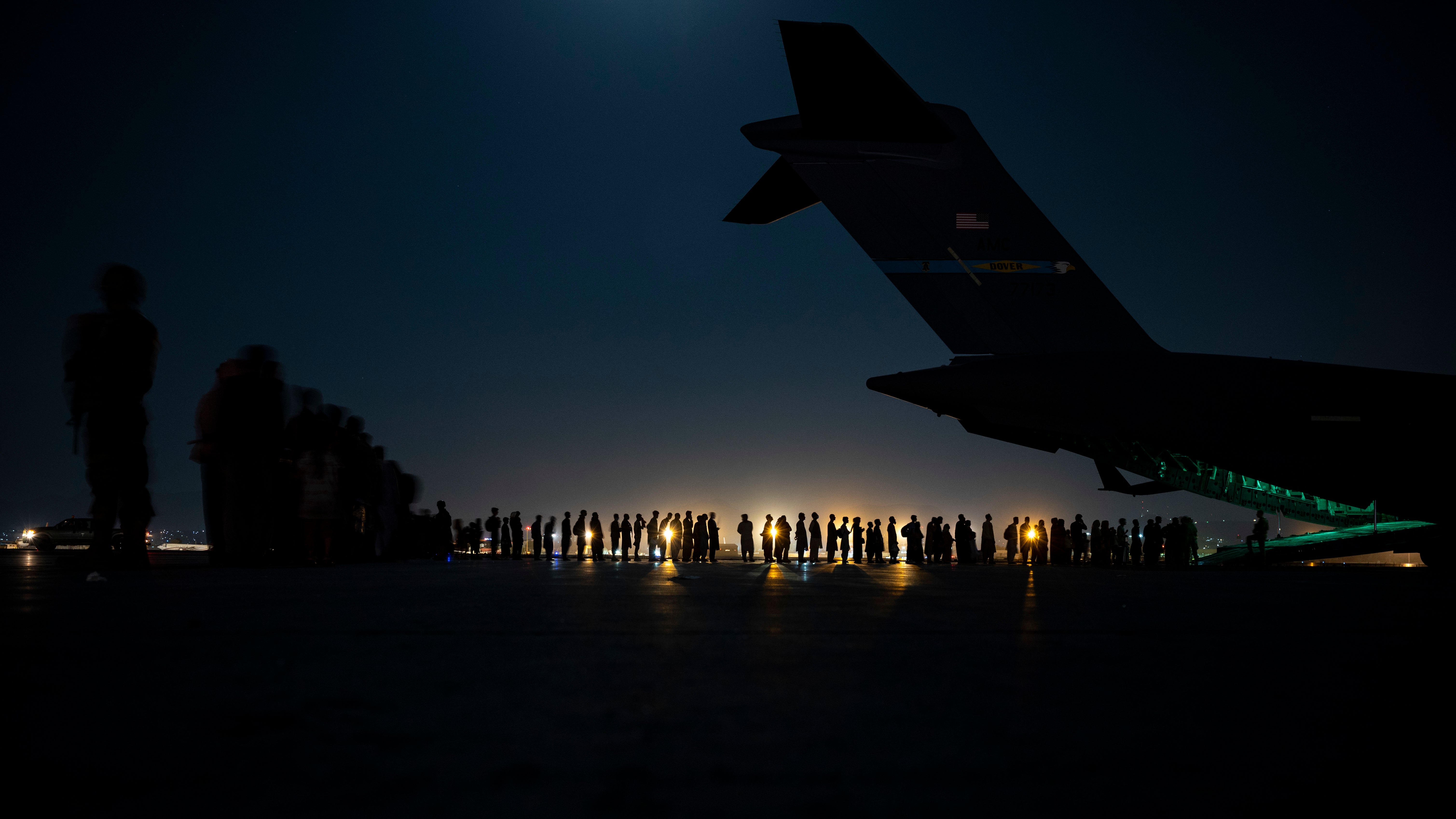 A crew prepares to load evacuees onboard a transport aircraft at Hamid Karzai international airport in Kabul on 21 August 2021