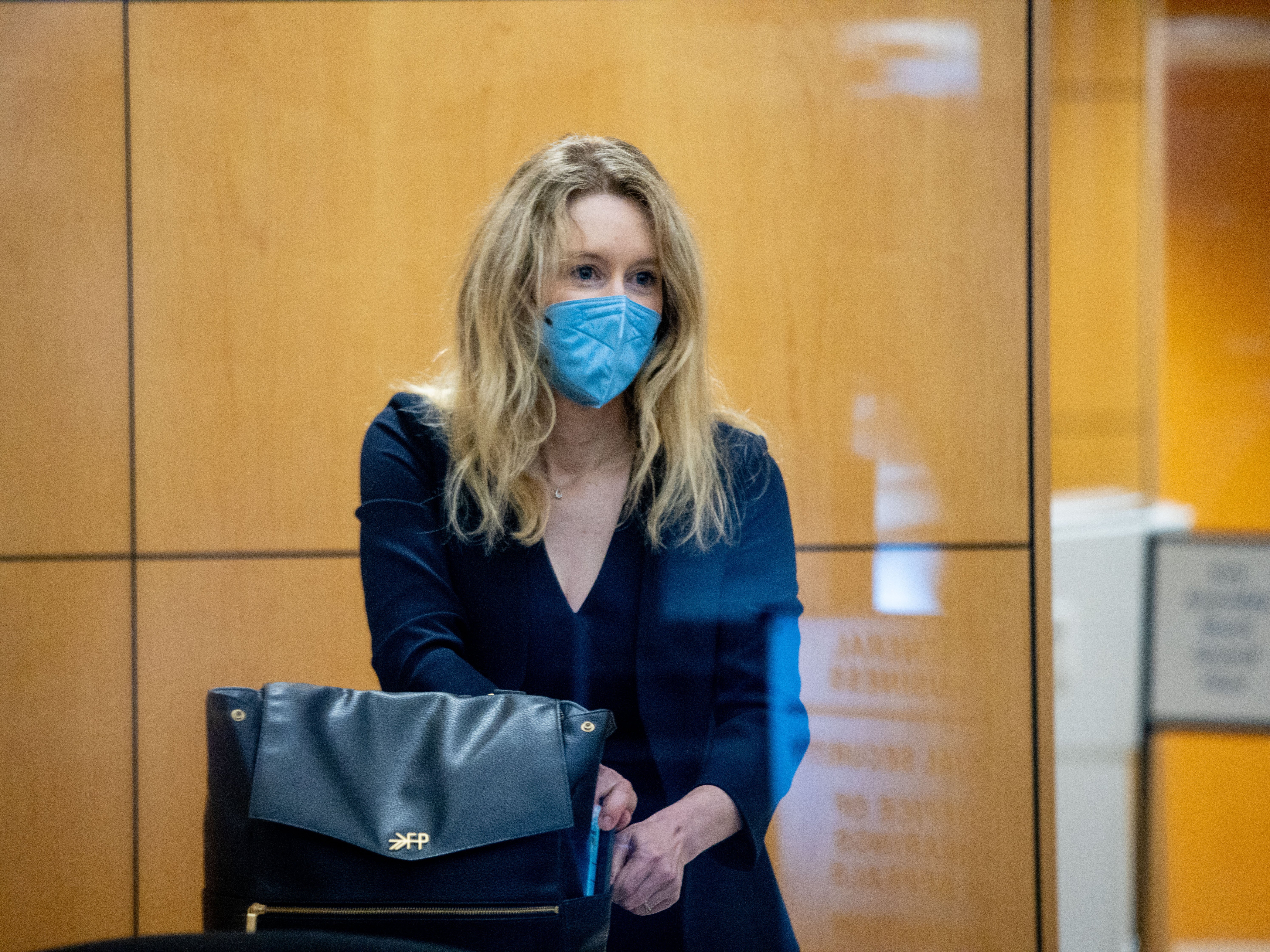 Theranos founder Elizabeth Holmes collects her belongings after going through security at the Robert F. Peckham Federal Building with her defense team on August 31, 2021 in San Jose, California