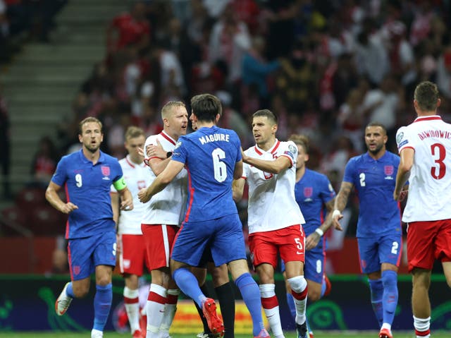 <p>Teammates attempt to separate Harry Maguire and Kamil Glik</p>