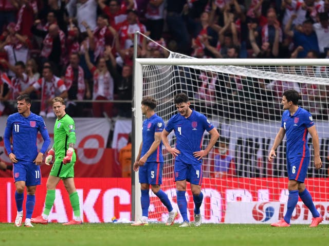 <p>England players react to Poland’s late equaliser in Warsaw</p>