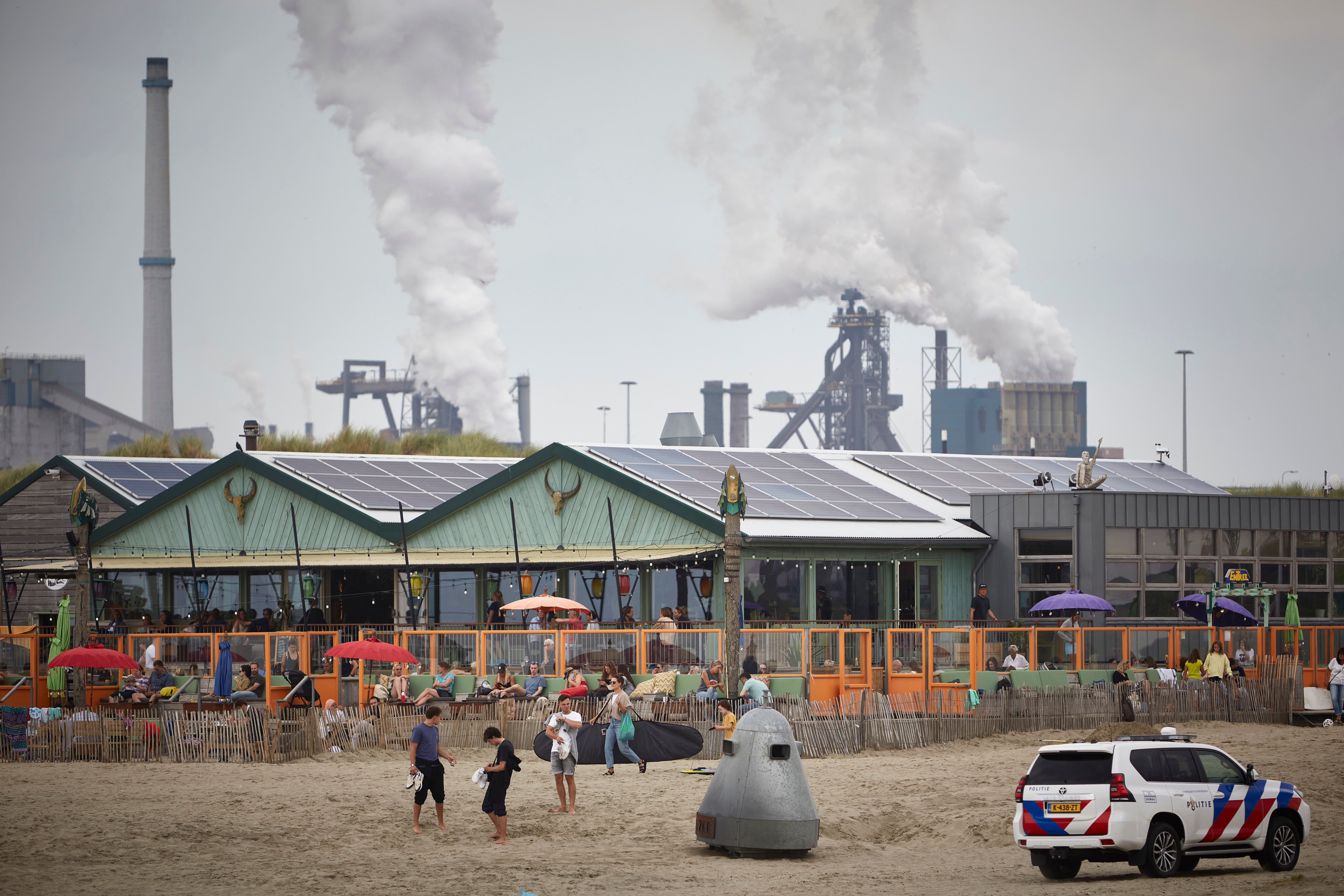 People enjoy the beach near the Tata Steel plant in Velsen-Noord