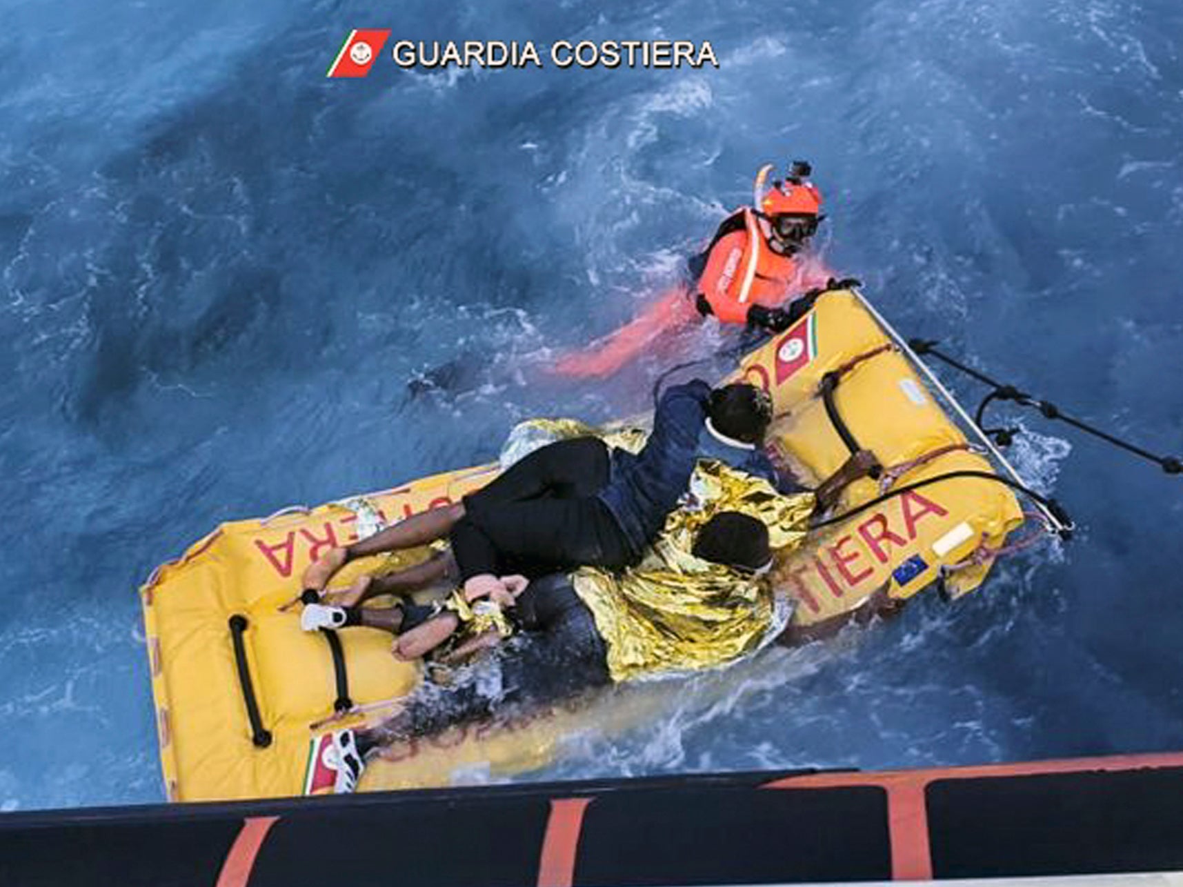 The Italian coast guard uses an inflatable raft to rescue migrants stuck on the shore of the Isola dei Conigli island